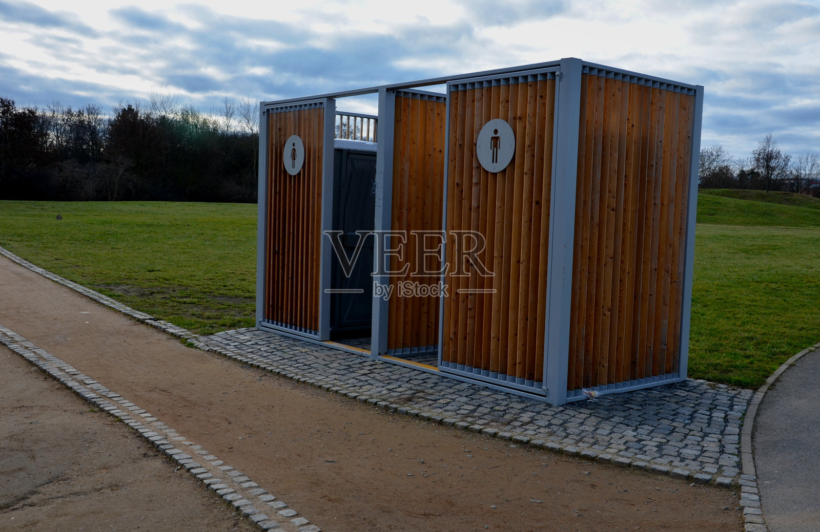 放置化学马桶的封闭笼。难看的塑料盒子放在一个金属房子里，房子有平屋顶，墙上有木板条。运动员在公园或母亲带着孩子可以小便、洗手照片摄影图片