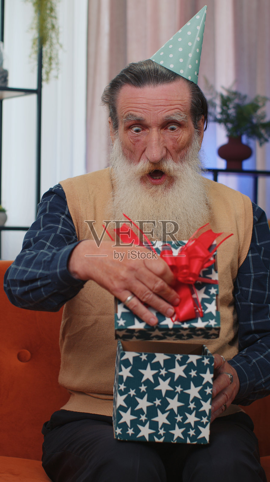 快乐的老人拿着带彩带的生日礼盒，庆祝晚会，在家里打开礼物照片摄影图片
