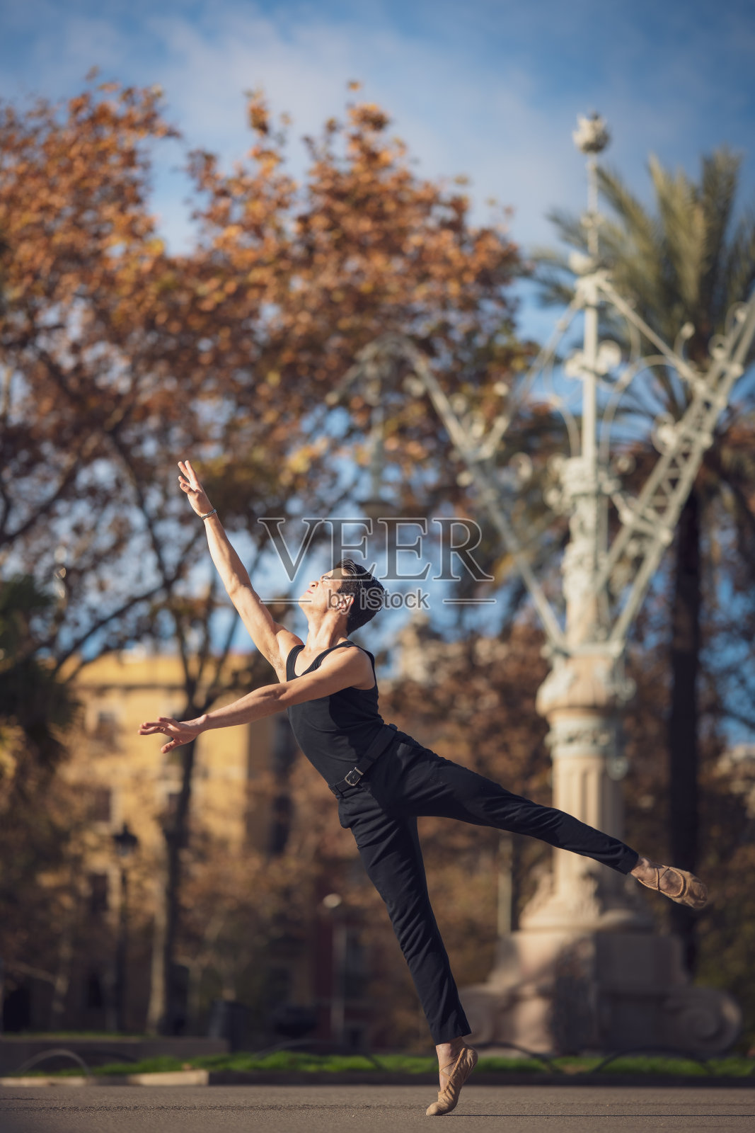 年轻男子在巴塞罗那的街道上跳着经典芭蕾，背景和灯光都很漂亮照片摄影图片