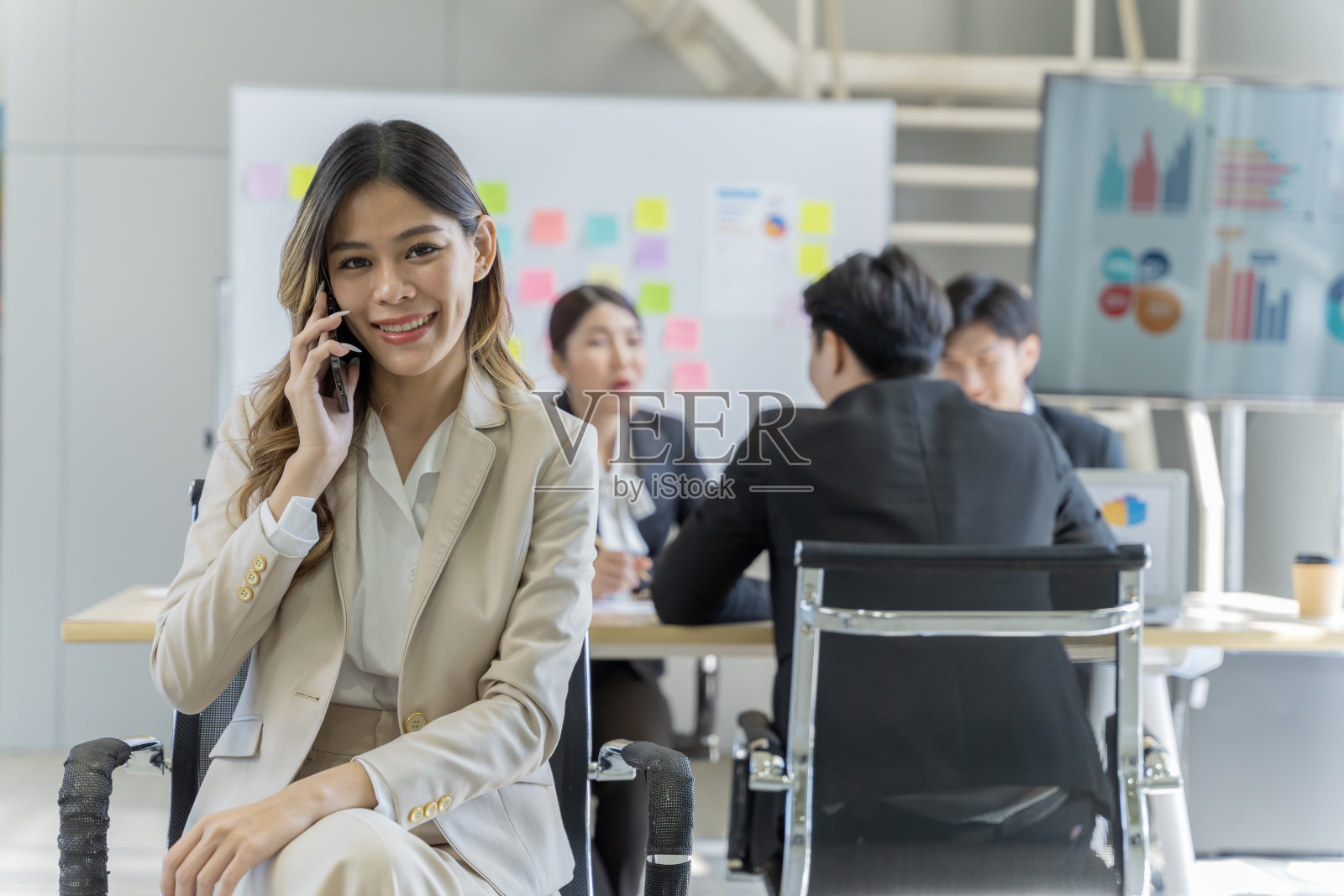 一群年轻的亚洲商人谈天说地，工作愉快，乐在其中。在公司的办公室照片摄影图片