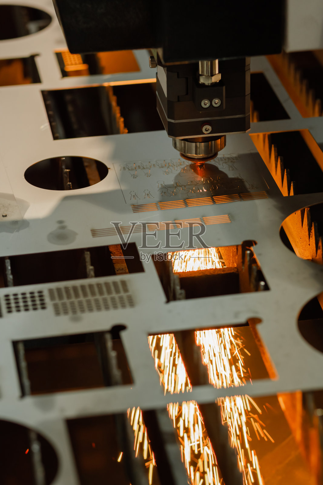 激光切割机工作与金属板与火花照片摄影图片