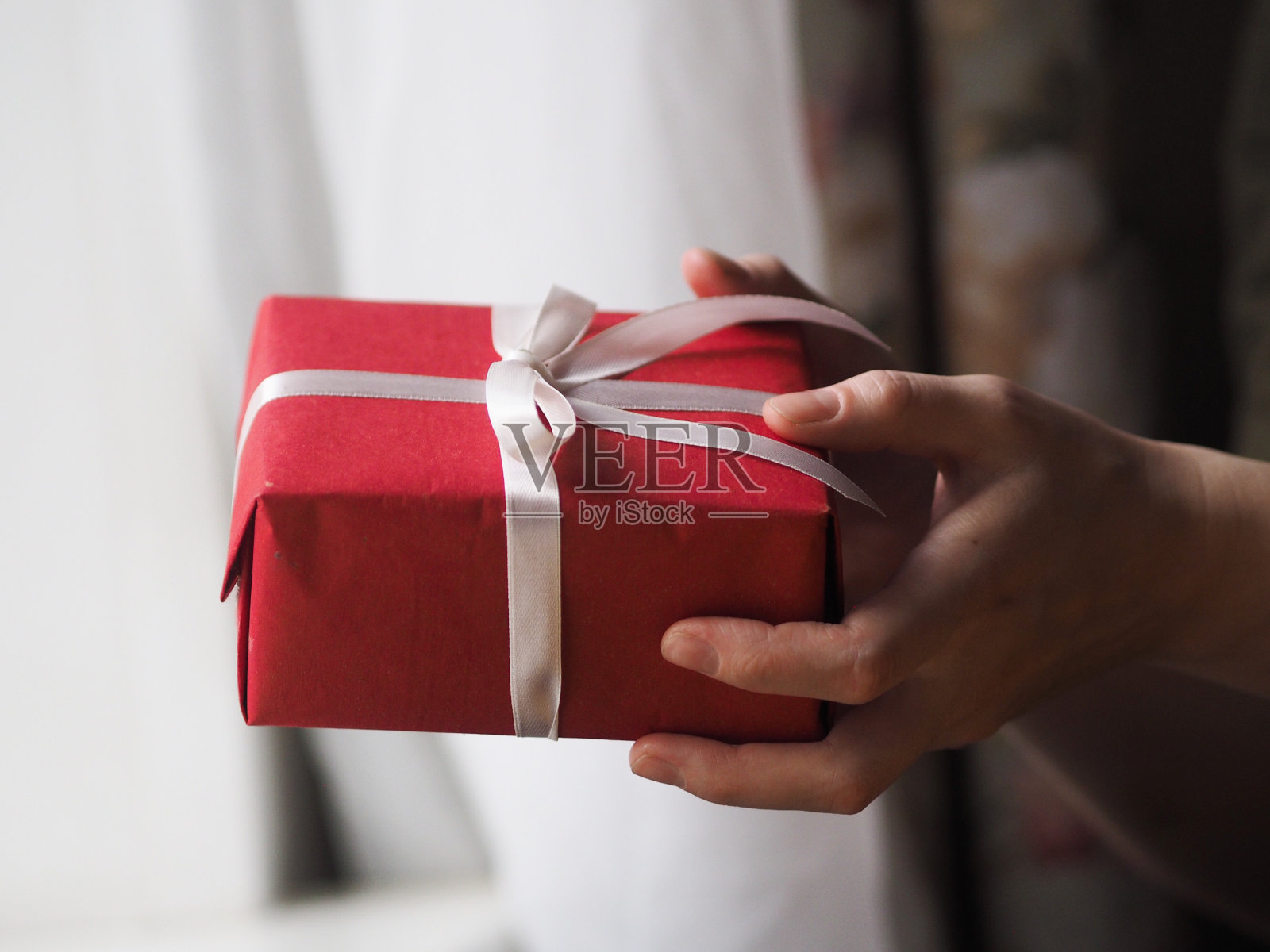 特写侧视图的妇女分发红色礼品盒白色丝带，在节日礼物。圣诞快乐，新年快乐，情人节，节日，节日，生日，惊喜概念。照片摄影图片