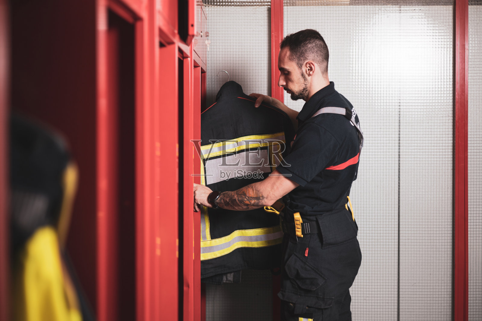 一名消防队员在消防站售票亭举行完服务后正在收拾衣服。照片摄影图片
