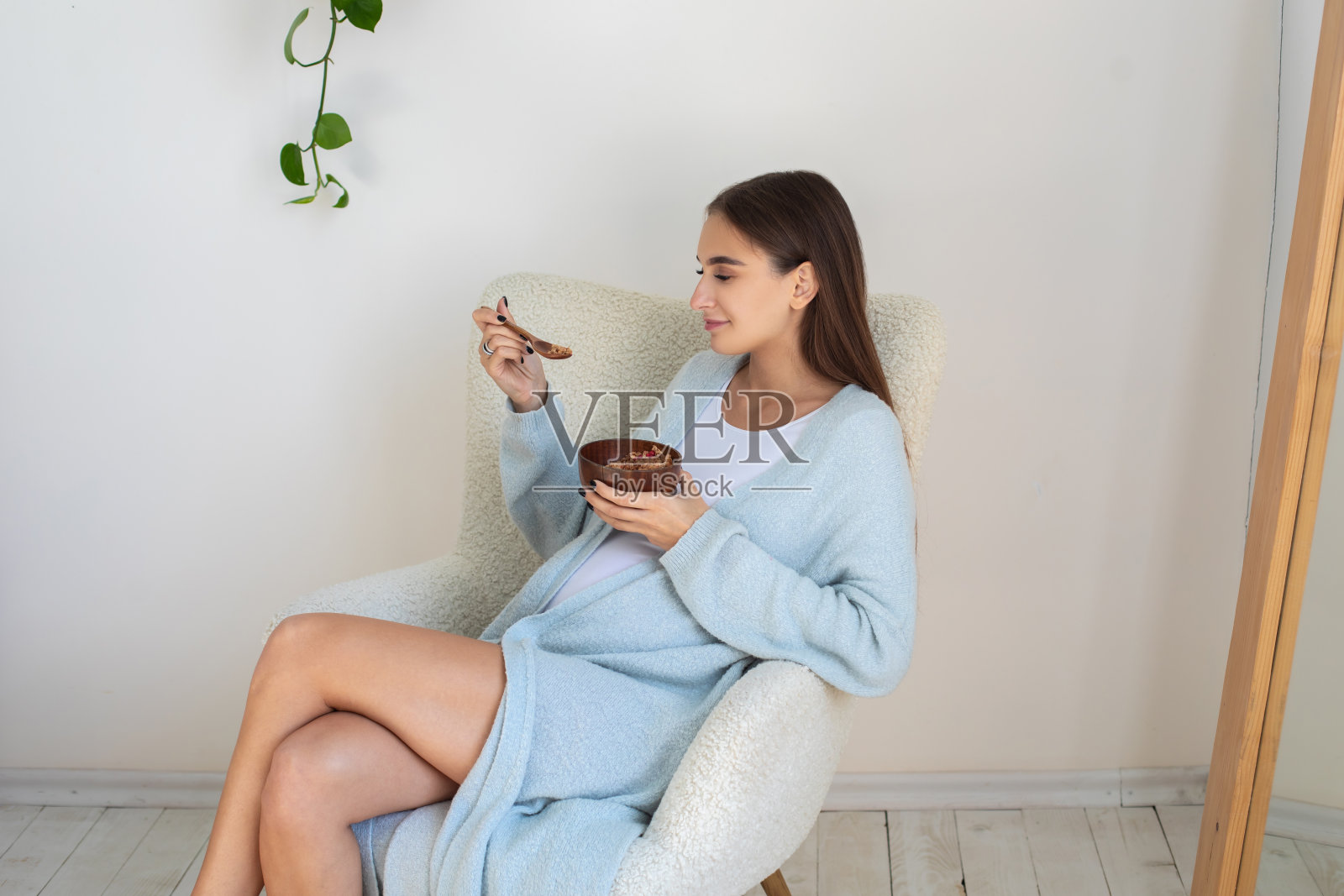 可爱的孕妇吃健康的食物，看起来很满足照片摄影图片