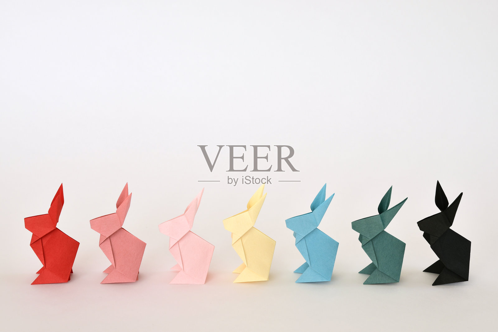 白色背景的折纸兔子。照片摄影图片