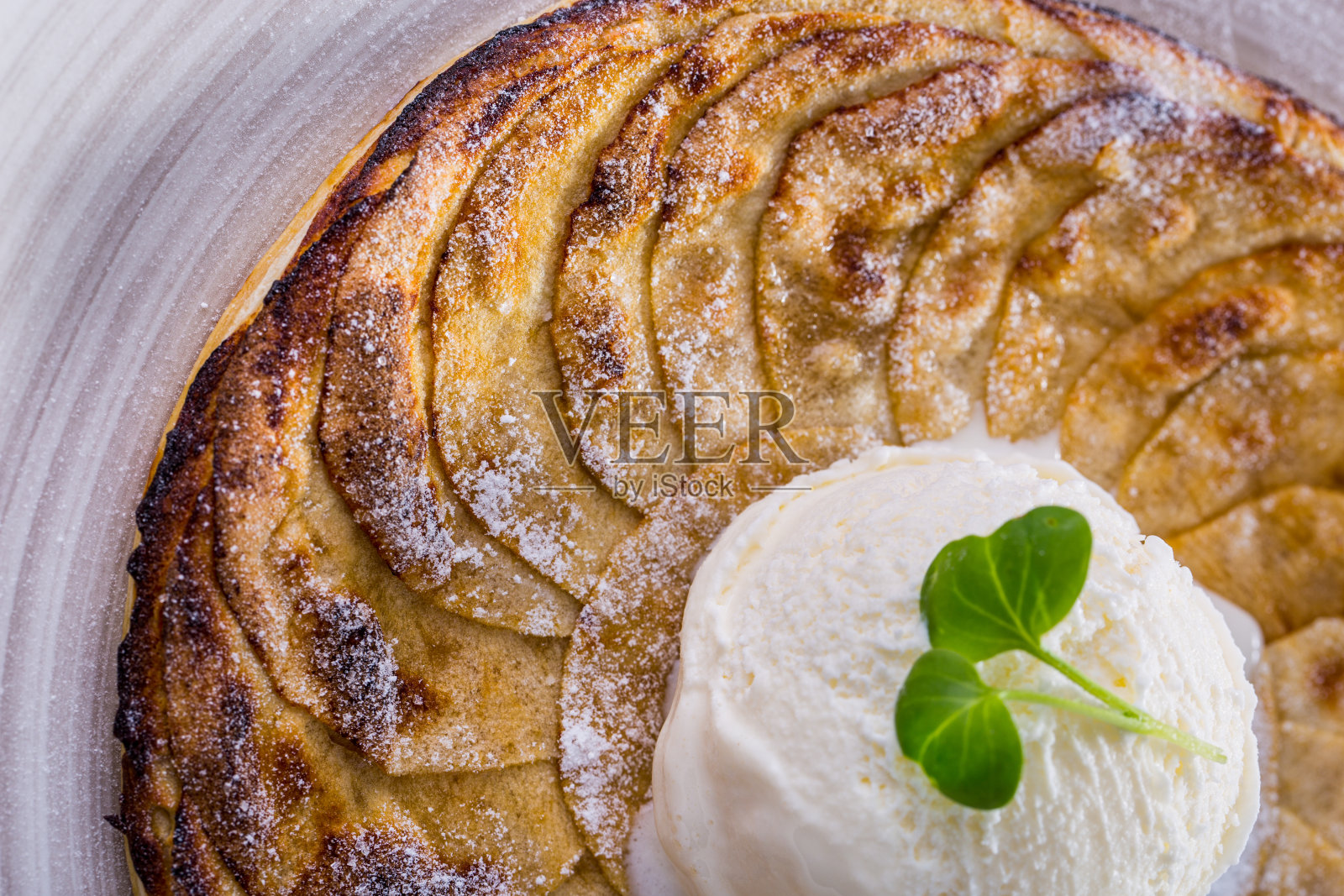 苹果圆糖圈和一勺冰淇淋在盘子里。水平方向照片摄影图片