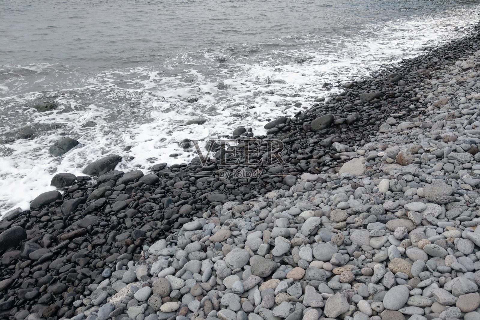 大海的波浪在岩石海滩上翻滚。照片摄影图片