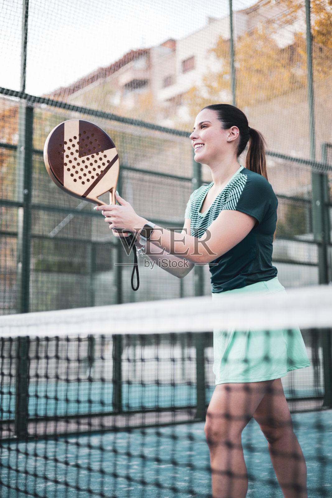 一位年轻的女子乒乓网球运动员在一场乒乓网球比赛中等待接发球。帆板网球概念。照片摄影图片