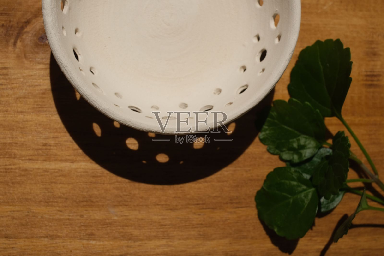 顶部视图的陶瓷容器和绿色树叶上的木桌照片摄影图片