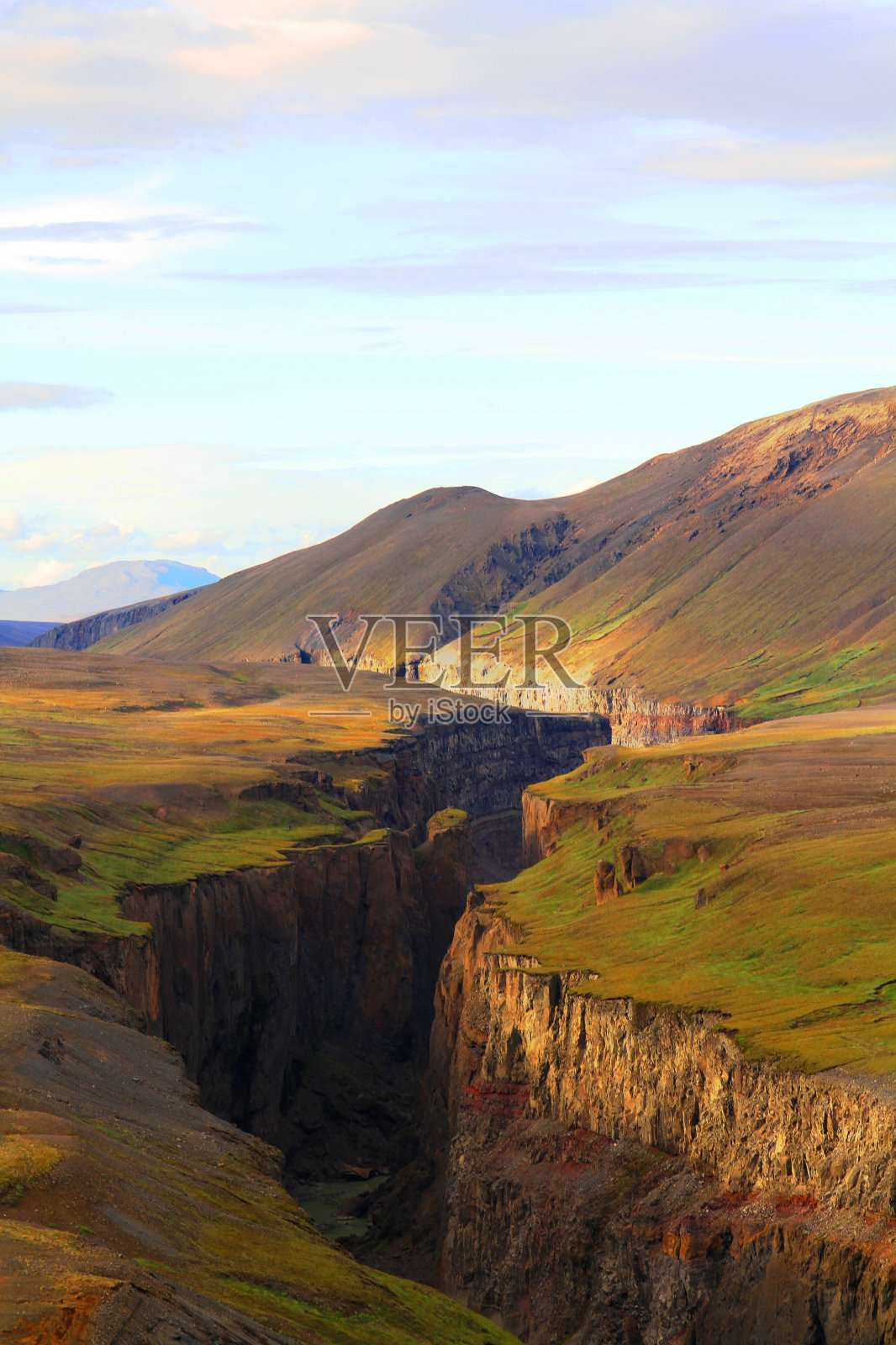 蓝色天空下的山脉中间的一个大峡谷的垂直拍摄照片摄影图片