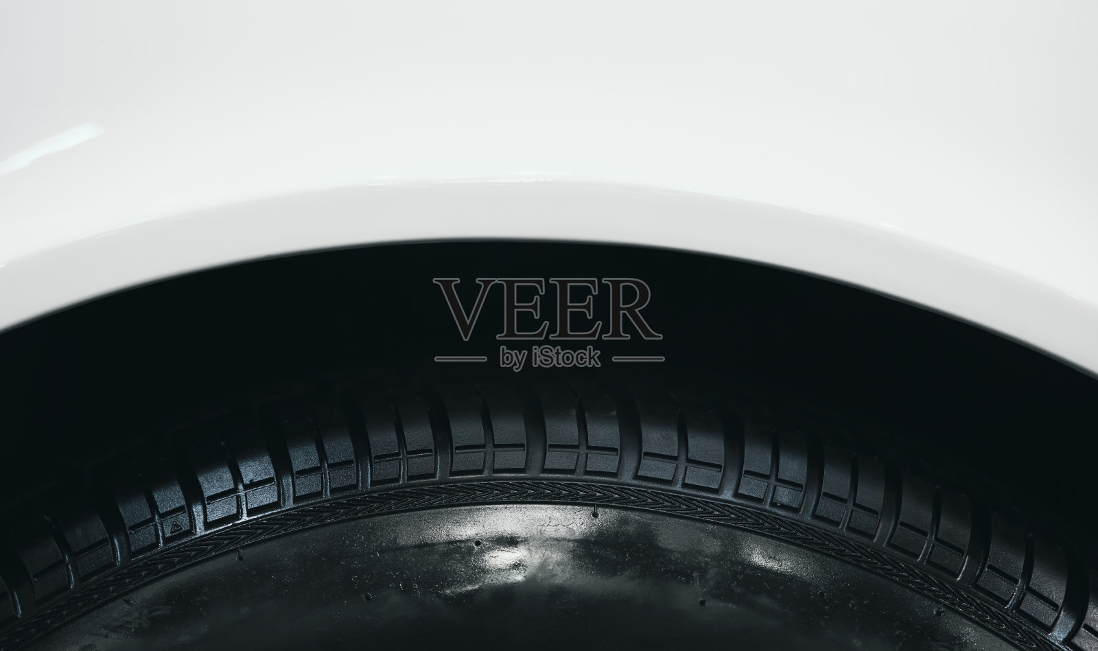 白色汽车前翼挡泥板上的黑色橡胶轮胎的细节照片摄影图片