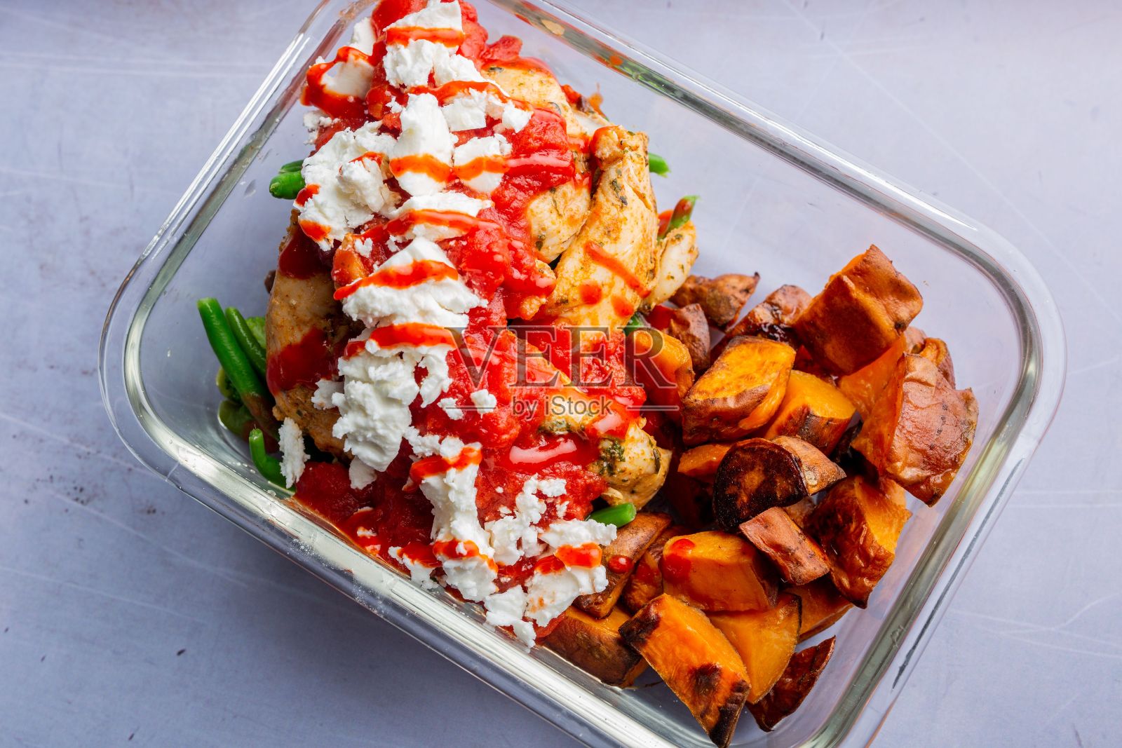 将鸡肉、土豆、蔬菜、番茄酱和奶酪放在透明的盘子里照片摄影图片