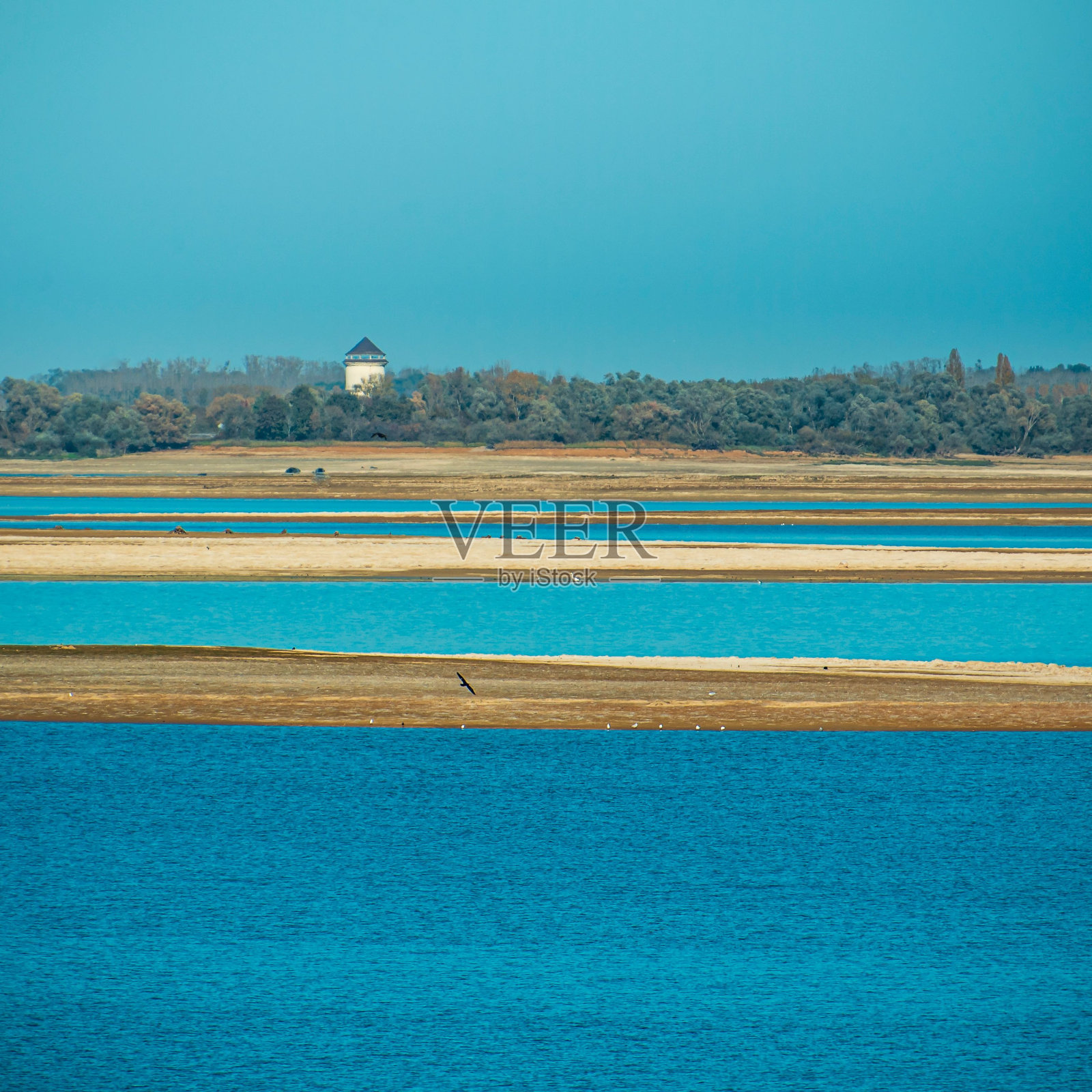 美丽的蓝色湖泊，陆地被树木环绕照片摄影图片