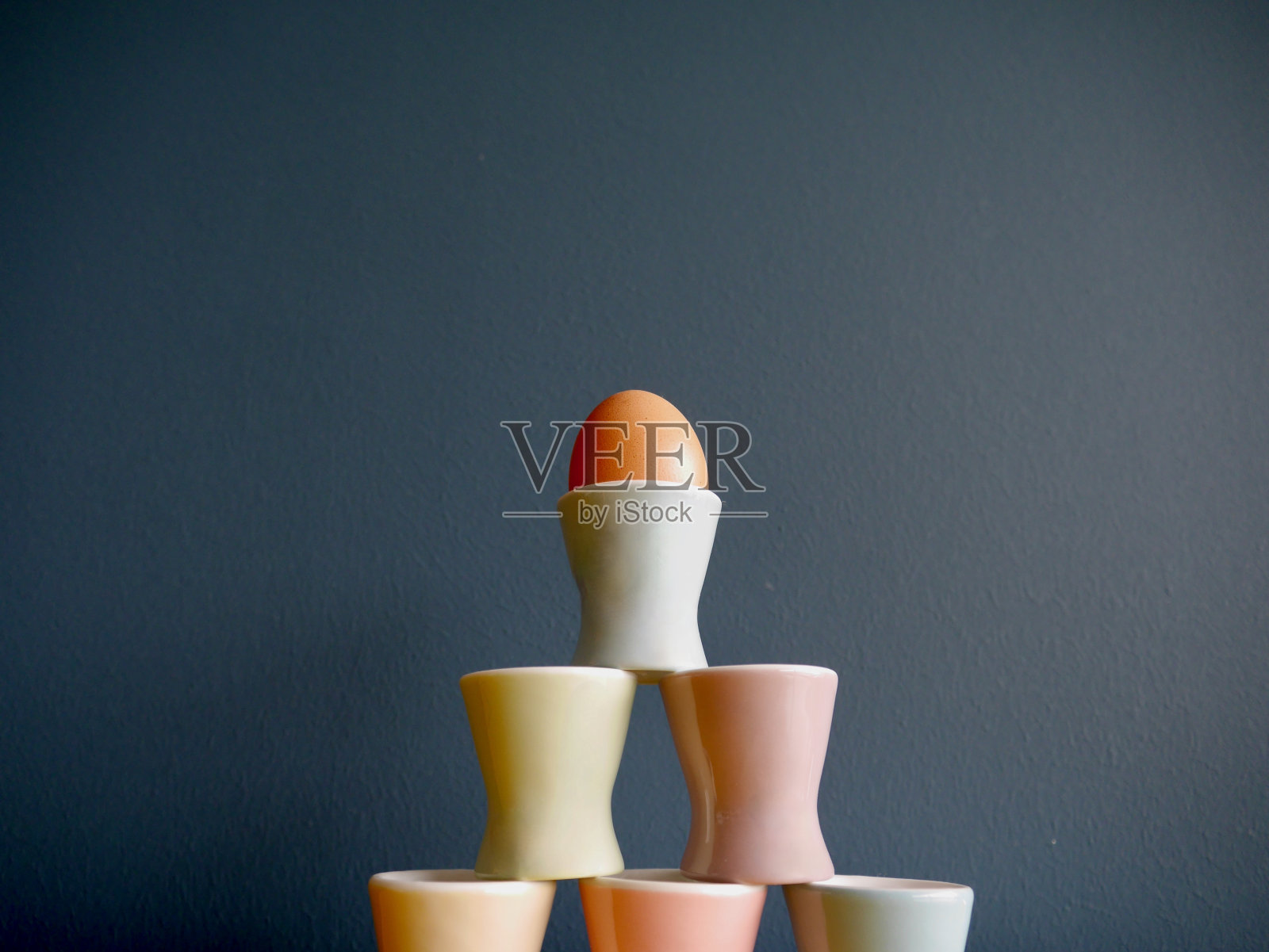 金字塔的复古粉彩蛋杯对蓝色的背景。照片摄影图片