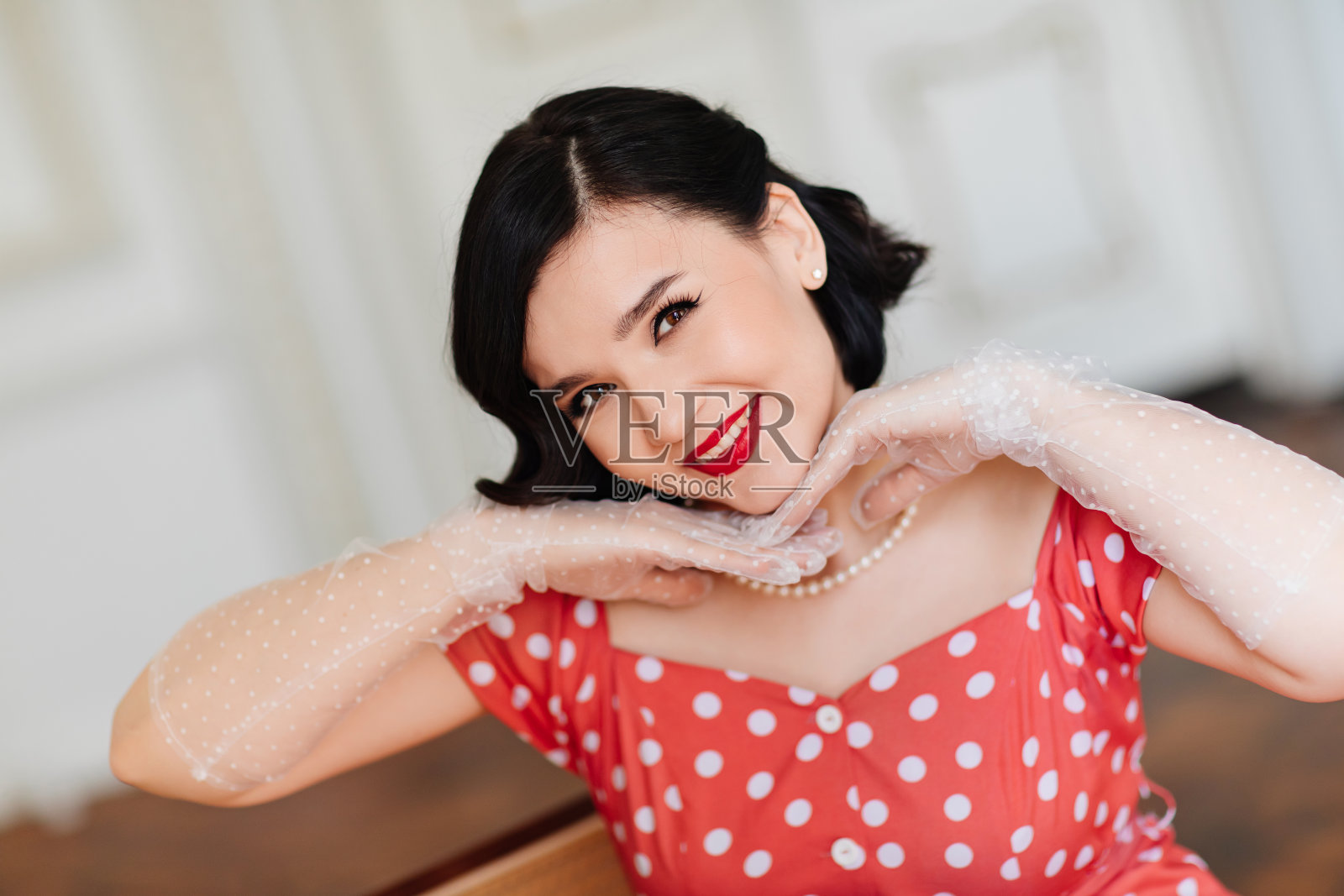 美丽和快乐的黑发肖像在红色复古礼服和手套照片摄影图片