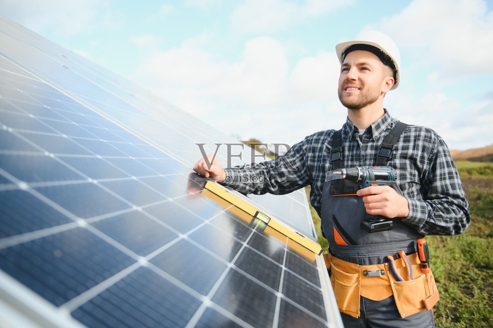 专家正在检验太阳能电池的质量。穿着制服和头盔的工人。生态节电理念。照片摄影图片