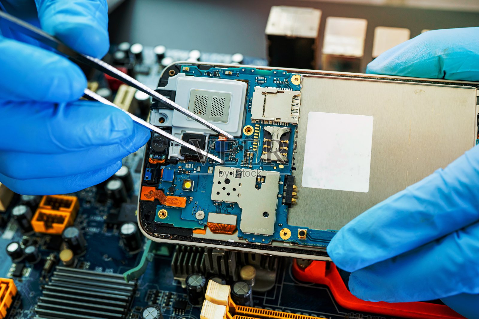 技术人员用烙铁修理手机内部。集成电路。数据、硬件、技术的概念。照片摄影图片