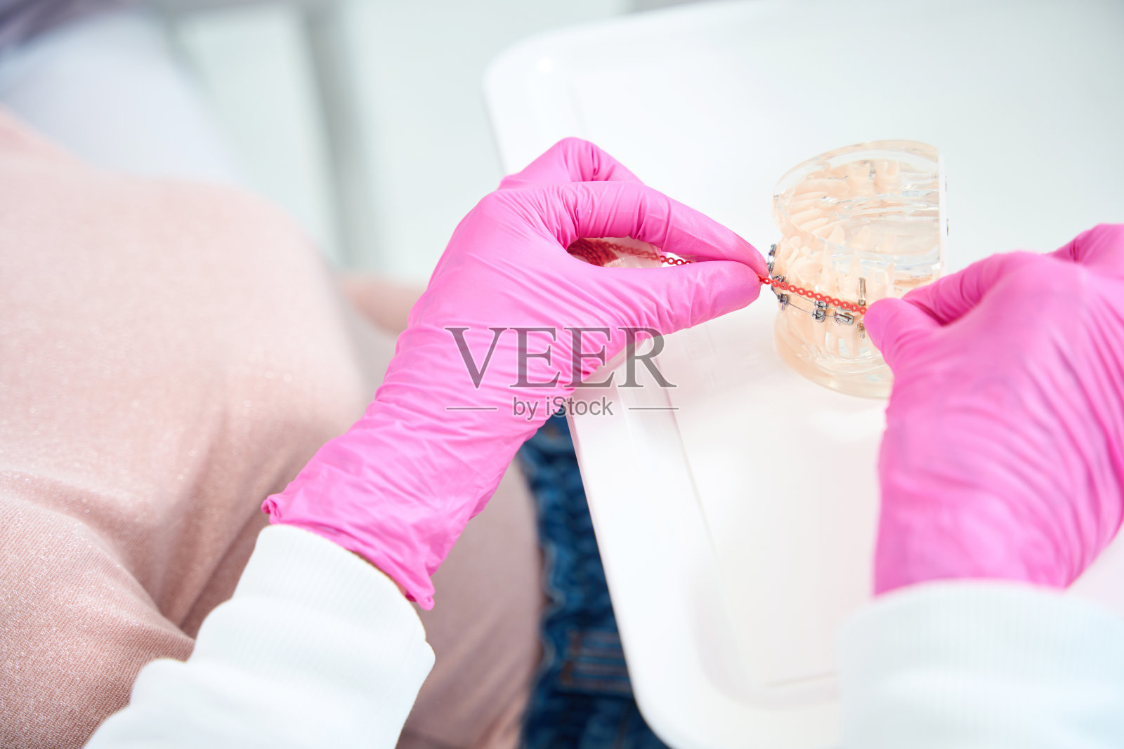 医生用牙套和橙色消耗品制作牙列模型照片摄影图片