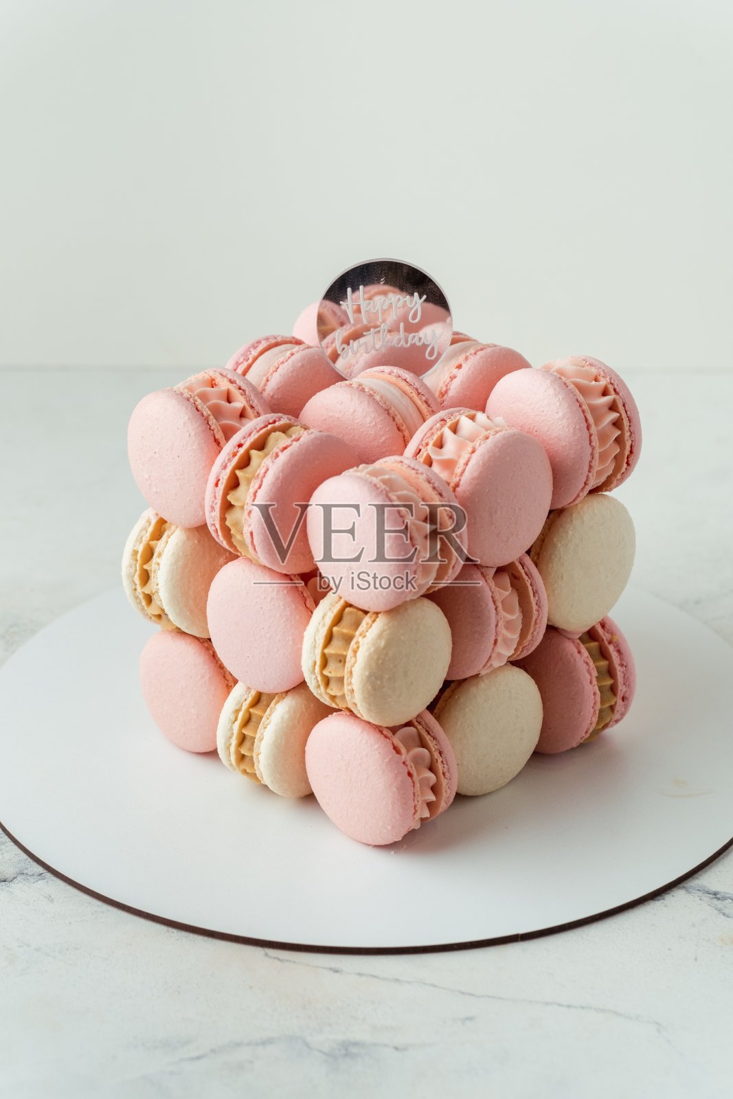 时尚的周年纪念蛋糕，白色背景的法式蛋白杏仁饼。不同寻常的粉色立方体婚礼蛋糕照片摄影图片