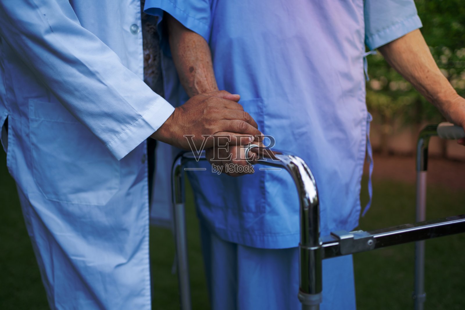 帮助和照顾亚洲老年人或老年老妇人在快乐的新鲜假期散步时使用健康的助行器。照片摄影图片