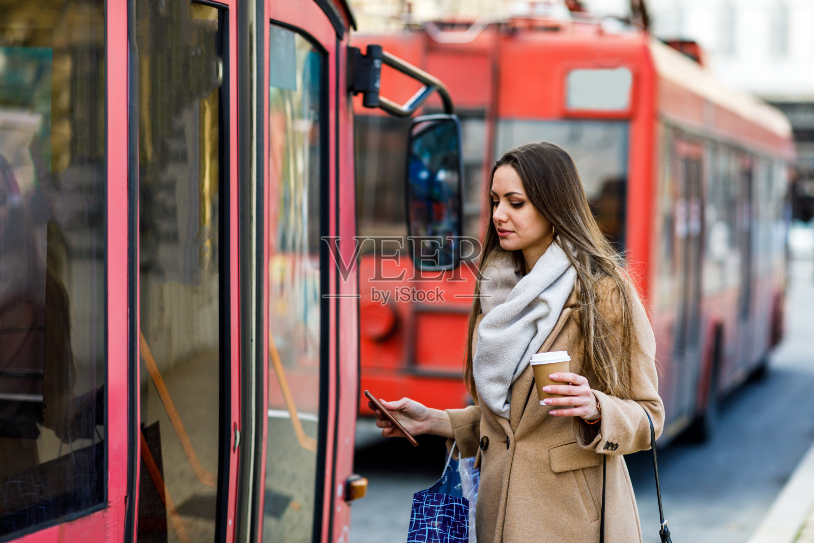一位美丽的年轻女子在车站等车。照片摄影图片