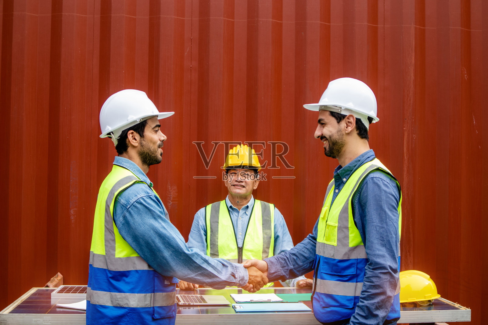 聪明的技术人员戴着安全帽和制服，有握手的团队合作理念照片摄影图片