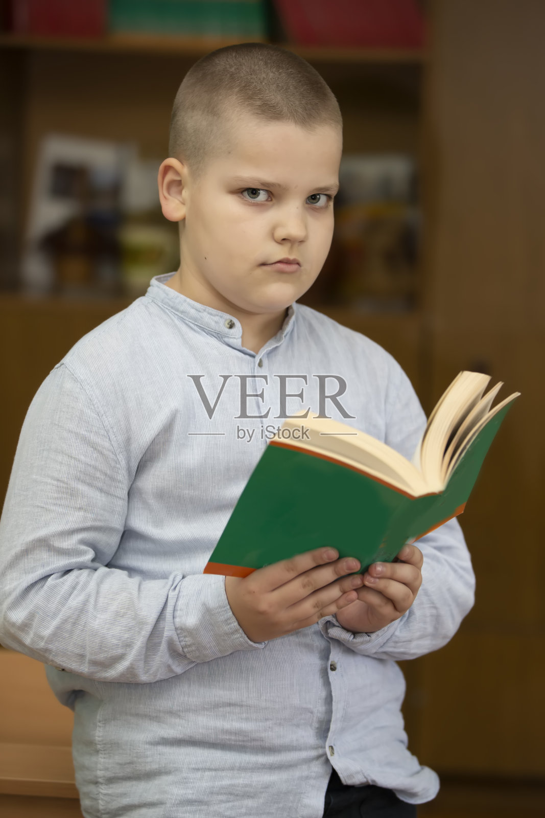 男生，拿着一本书的中学生。照片摄影图片