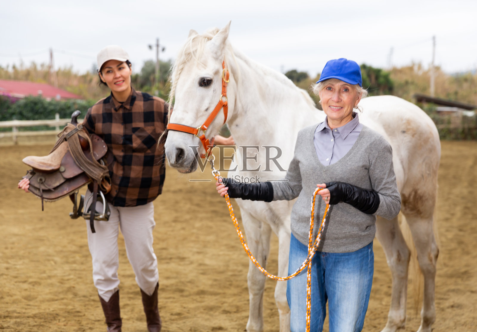 女牧场主正在准备骑白马照片摄影图片