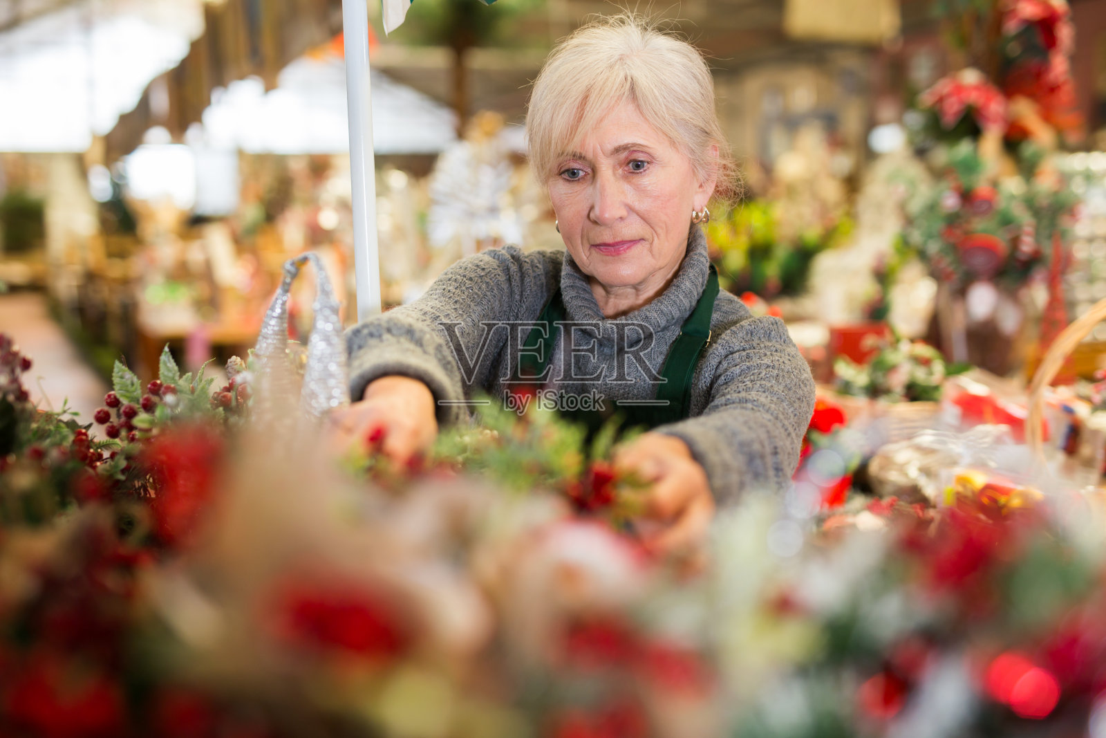 老年女店员在陈列室布置圣诞装饰品照片摄影图片