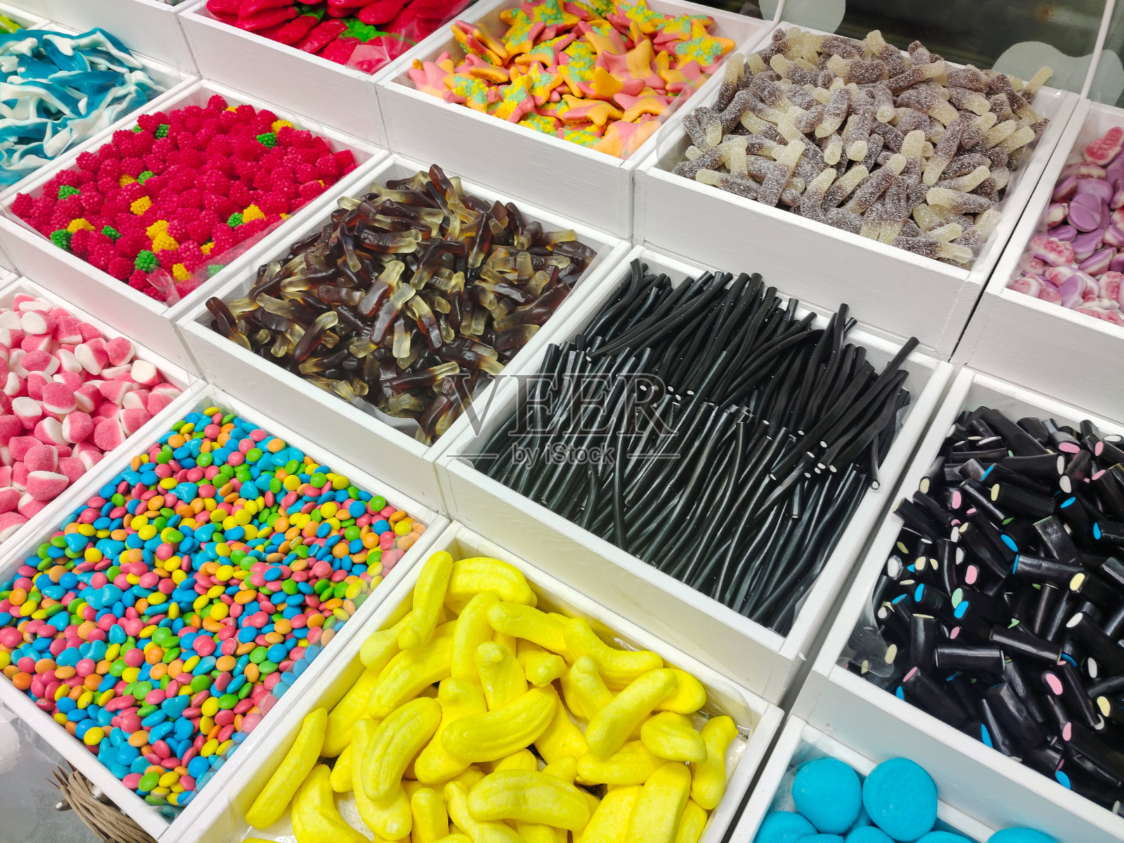 各种颜色和形状的糖果放在商店里单独的销售托盘上出售照片摄影图片