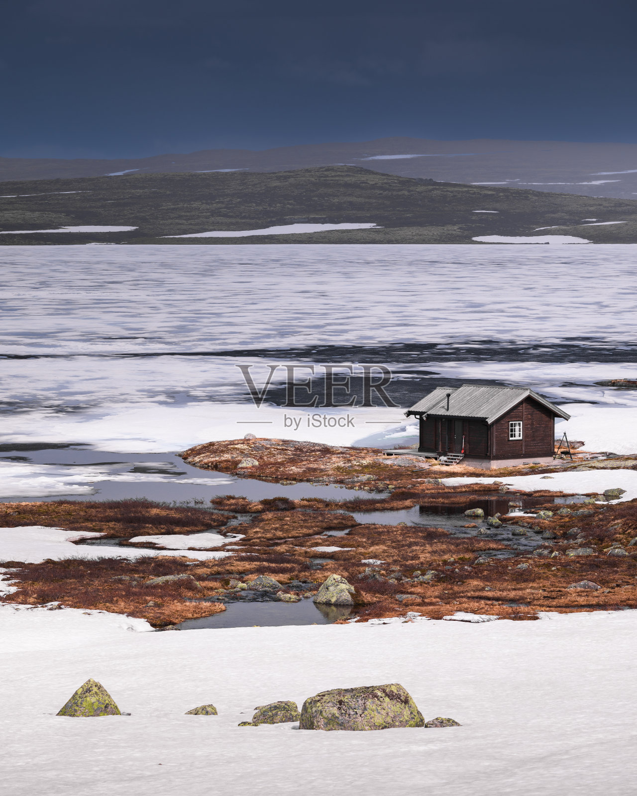 挪威哈当厄维达国家公园冰冻湖畔的小屋照片摄影图片