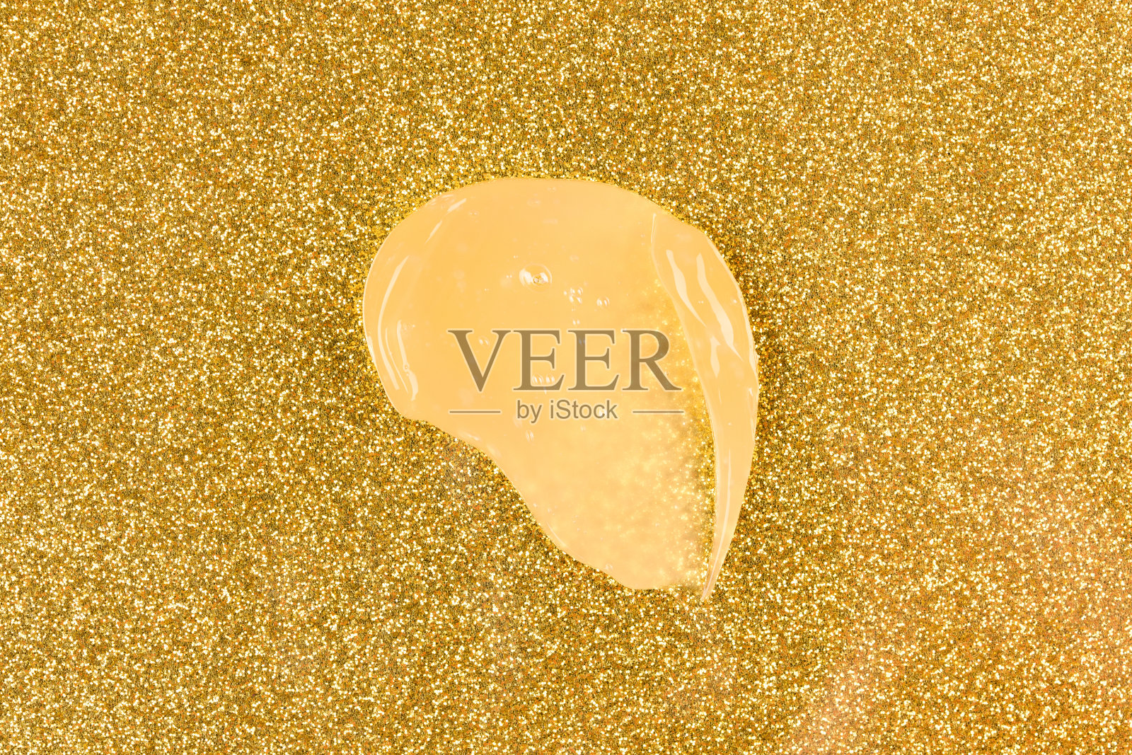 金色奶油污渍。生物金护肤产品，面部或眼霜涂抹在金色闪闪发光的背景。美容产品含金照片摄影图片