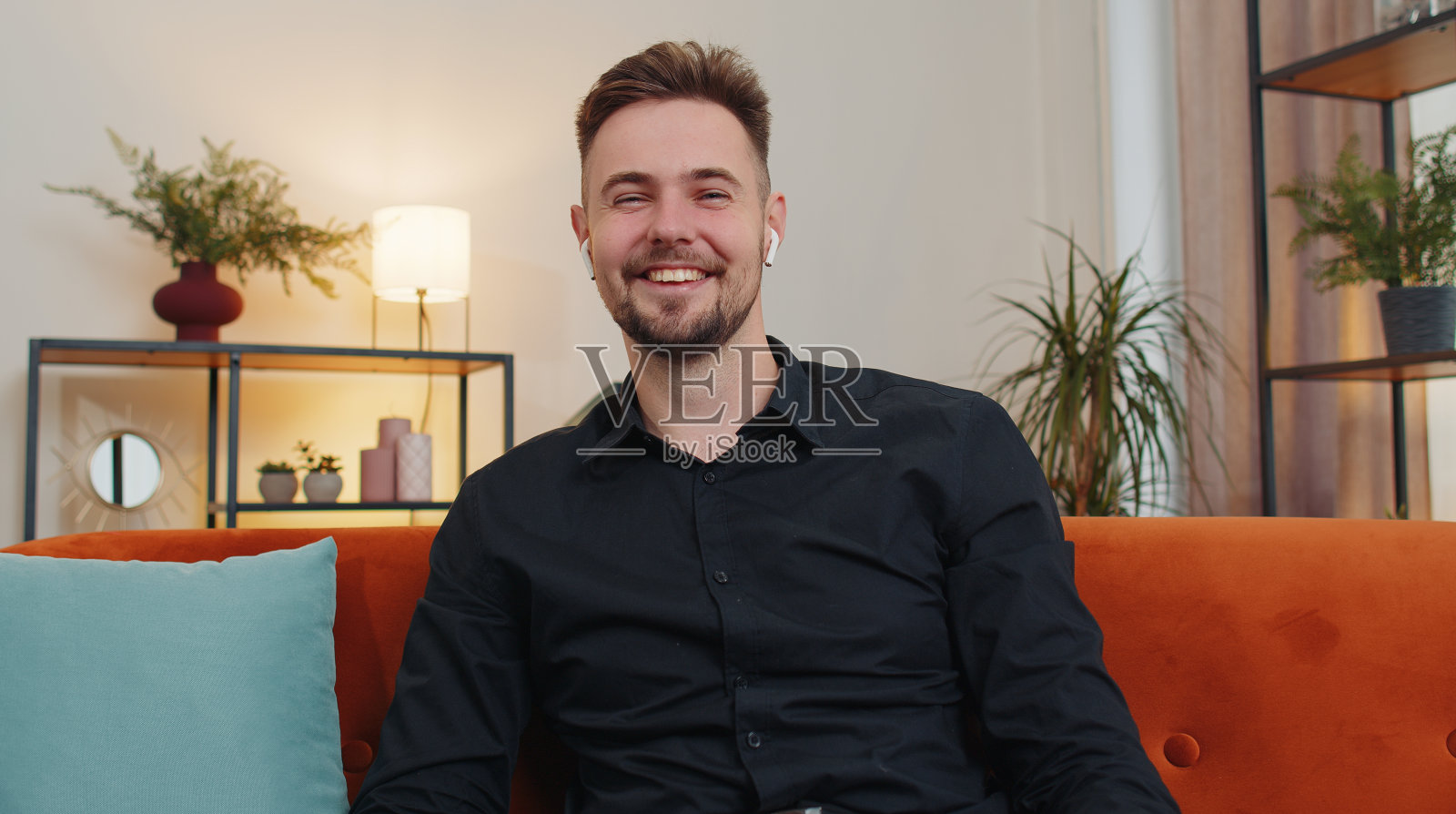 坐在家里的沙发上，看着摄像头，和朋友或家人开视频电话会议照片摄影图片