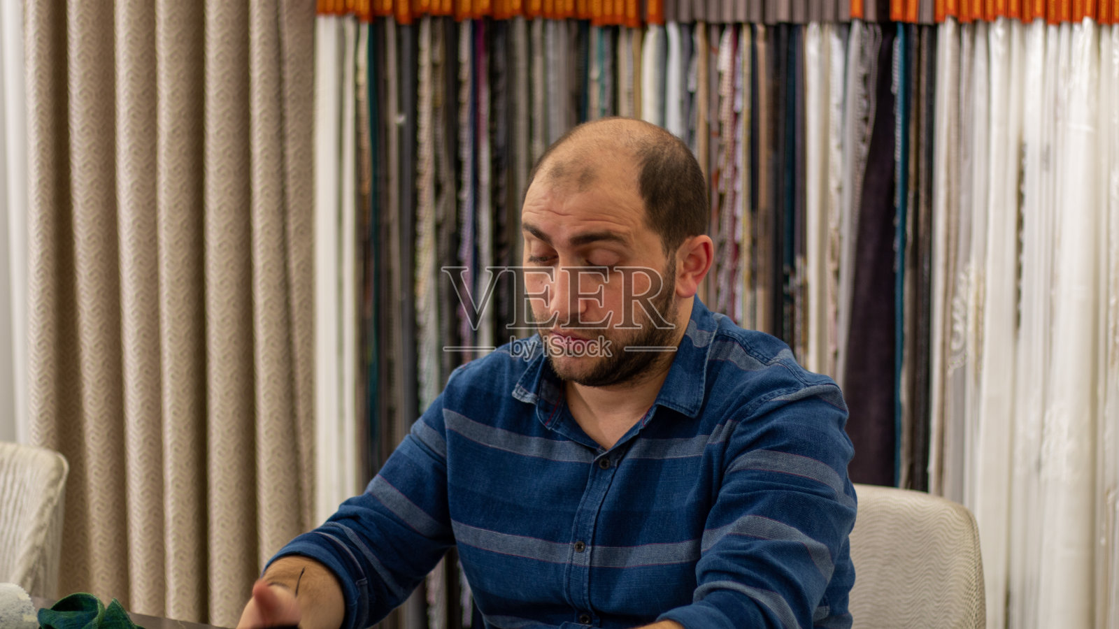 坐在桌旁的蓝眼睛留着胡子的年轻人告诉我照片摄影图片