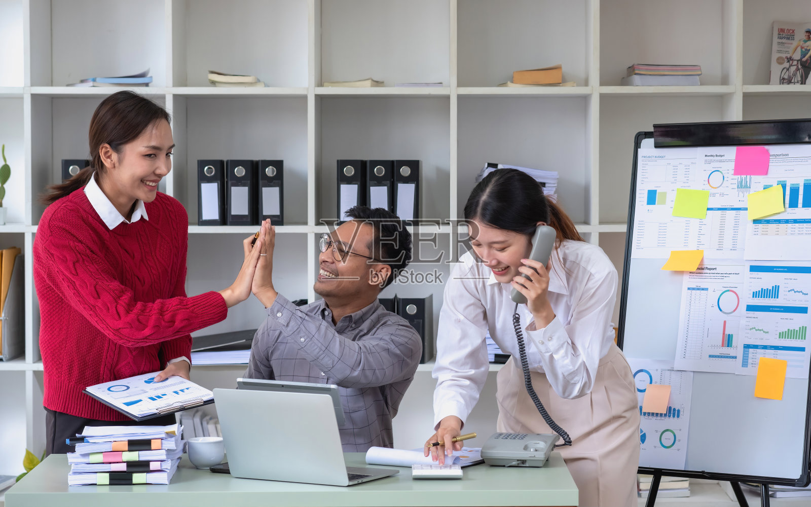 一群商人用他们的笔记本电脑和图表规划他们的利润，用计算器计算他们公司的年度余额。照片摄影图片