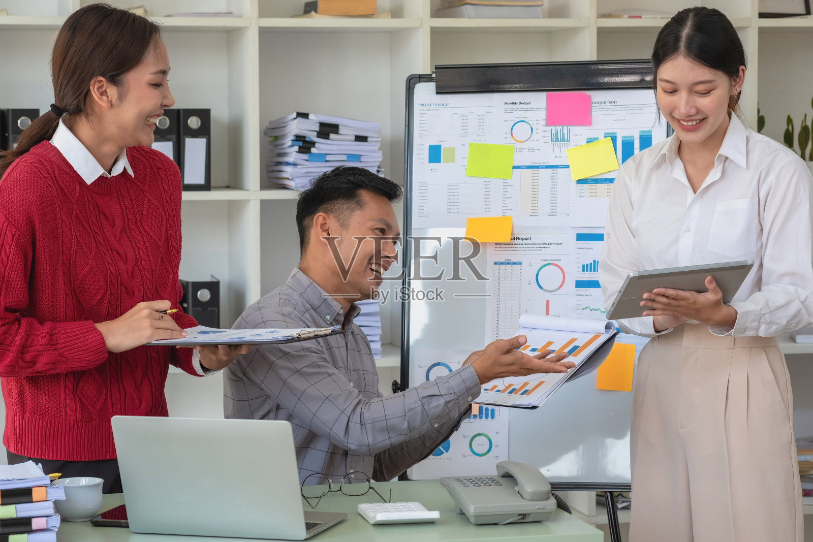 营销、财务、会计、计划一群商人用他们的笔记本电脑和图表计划他们的利润，用计算器计算他们公司的年度余额。照片摄影图片