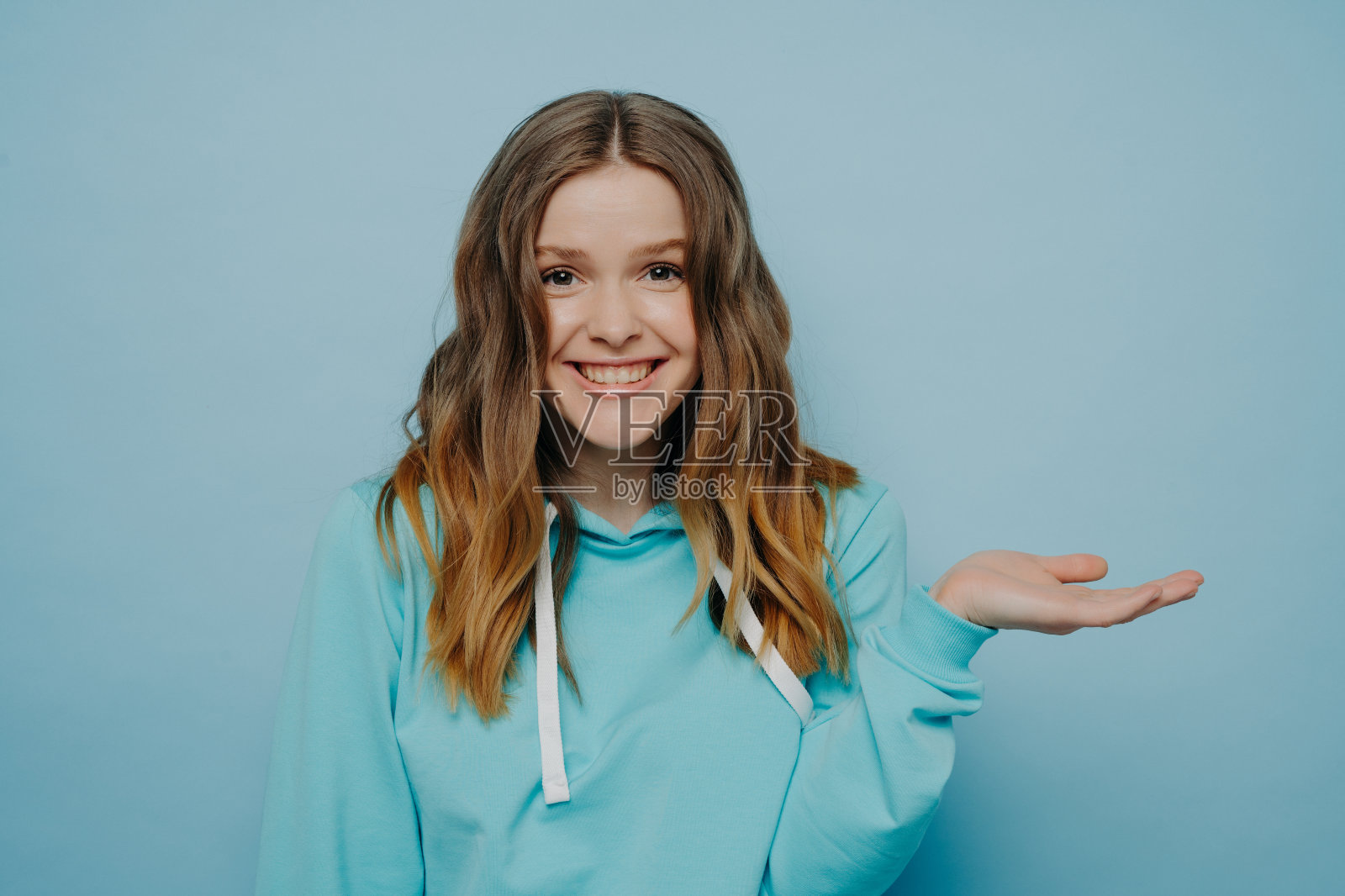 兴奋的年轻女孩耸肩与倾斜的手照片摄影图片