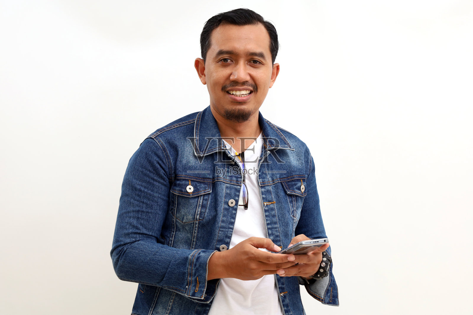 快乐的亚洲男人站着拿着手机。白色背景隔离照片摄影图片