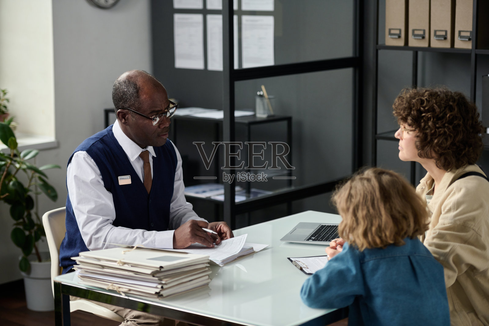 资深黑人向带孩子的母亲咨询照片摄影图片