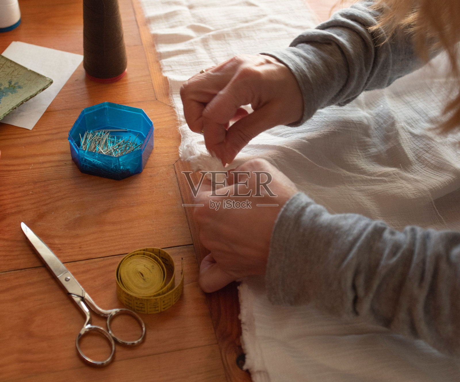 女人小心地缝白布照片摄影图片