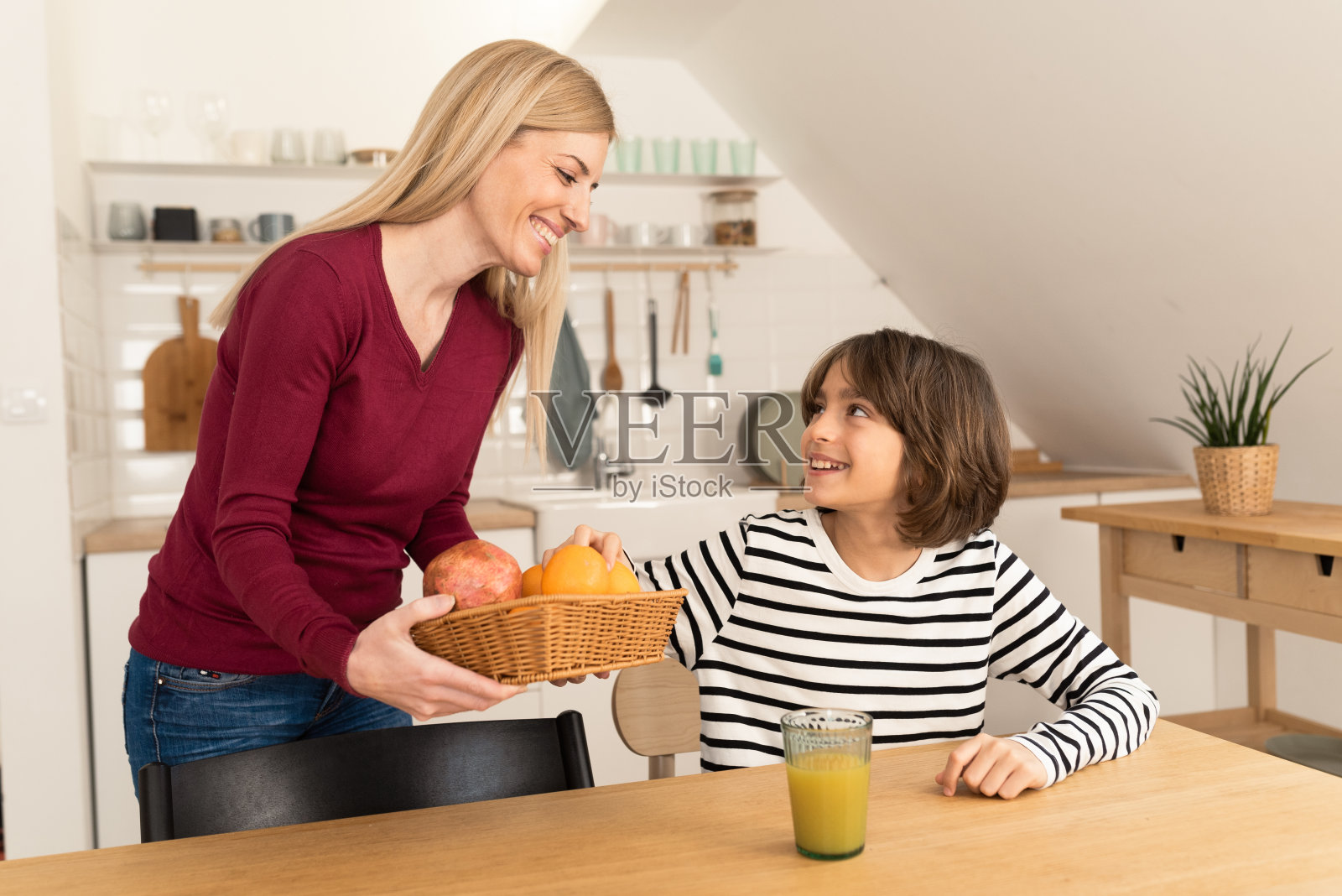 母亲给儿子新鲜水果照片摄影图片