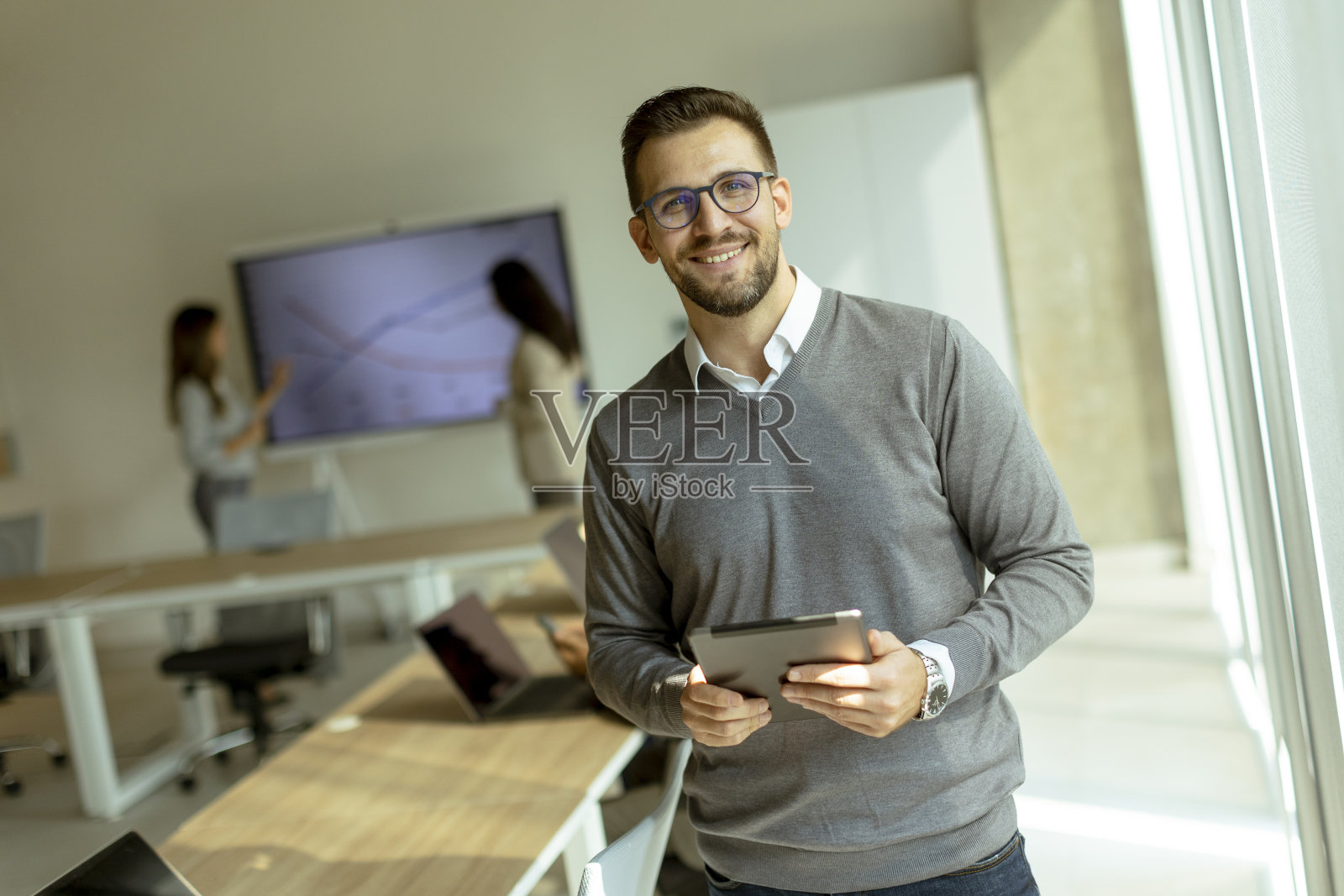 年轻的现代商人在办公室使用数字平板电脑照片摄影图片