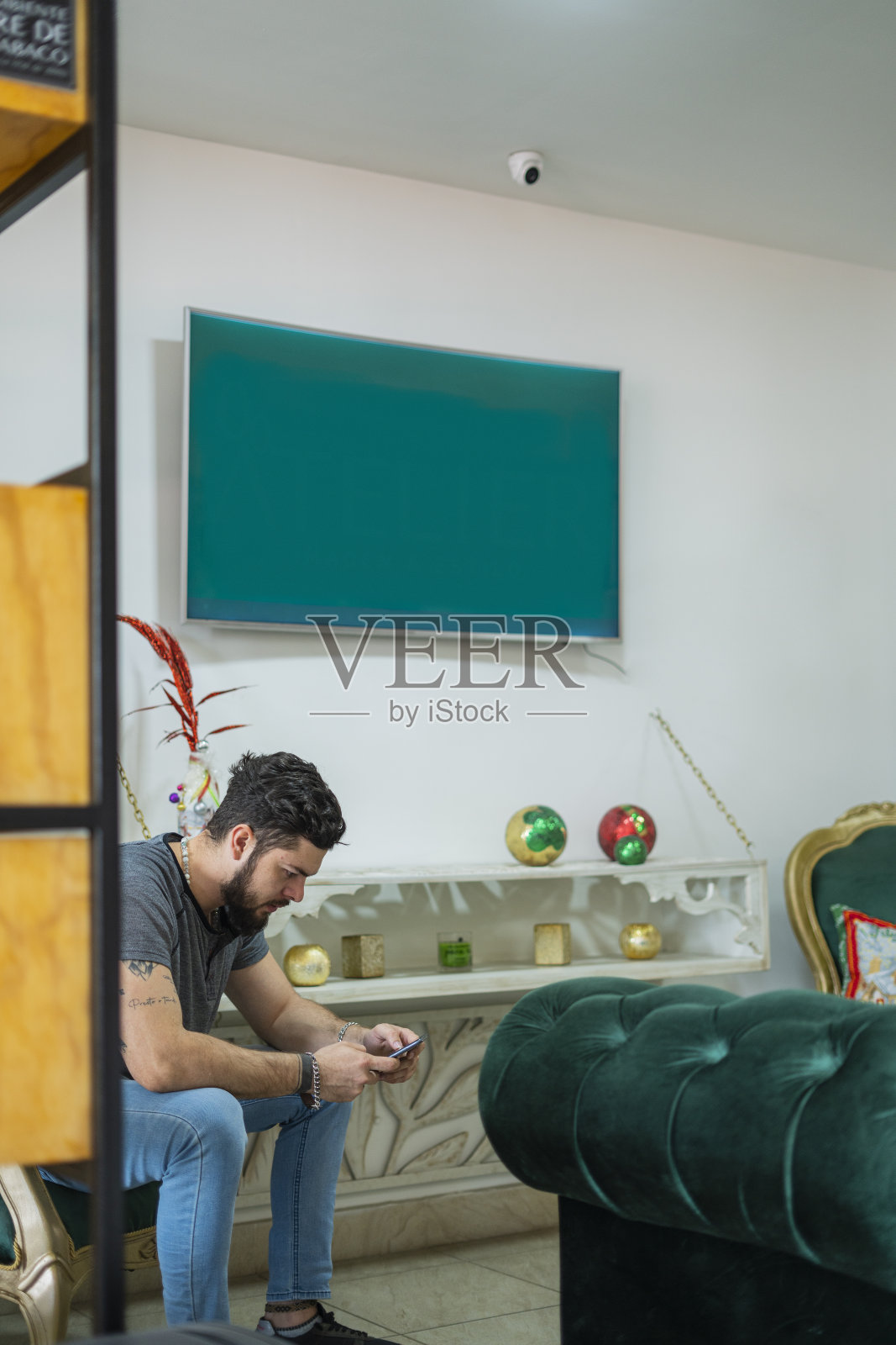 一家美容院的拉丁裔客户坐在候诊室里，手里拿着手机照片摄影图片