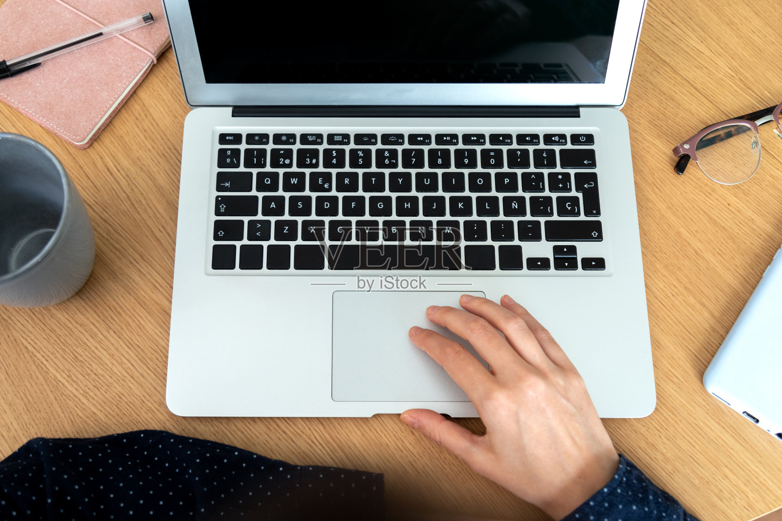 女性在办公室使用笔记本电脑的俯视图。手机、笔记本和眼镜。照片摄影图片