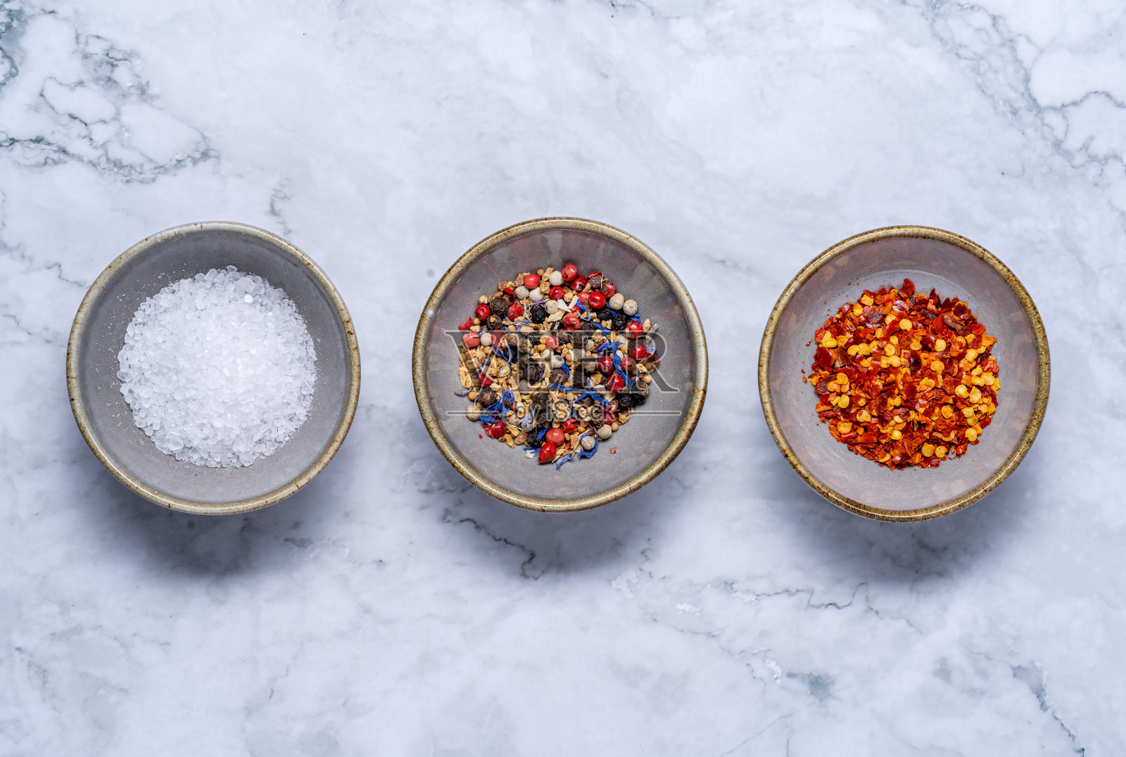 头顶上的岩盐，辣椒片，柠檬胡椒在大理石背景上照片摄影图片