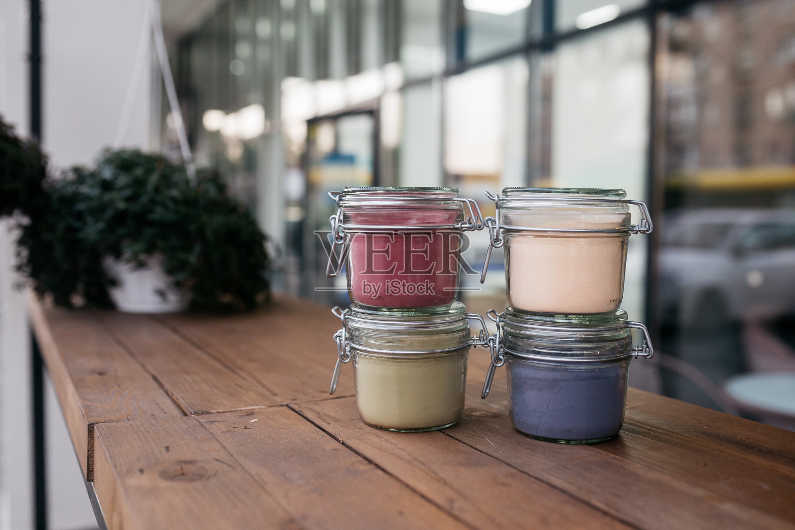 玻璃罐里的散茶。绿茶与芙蓉和野玫瑰，洋甘菊玻璃罐放在桌上。照片摄影图片