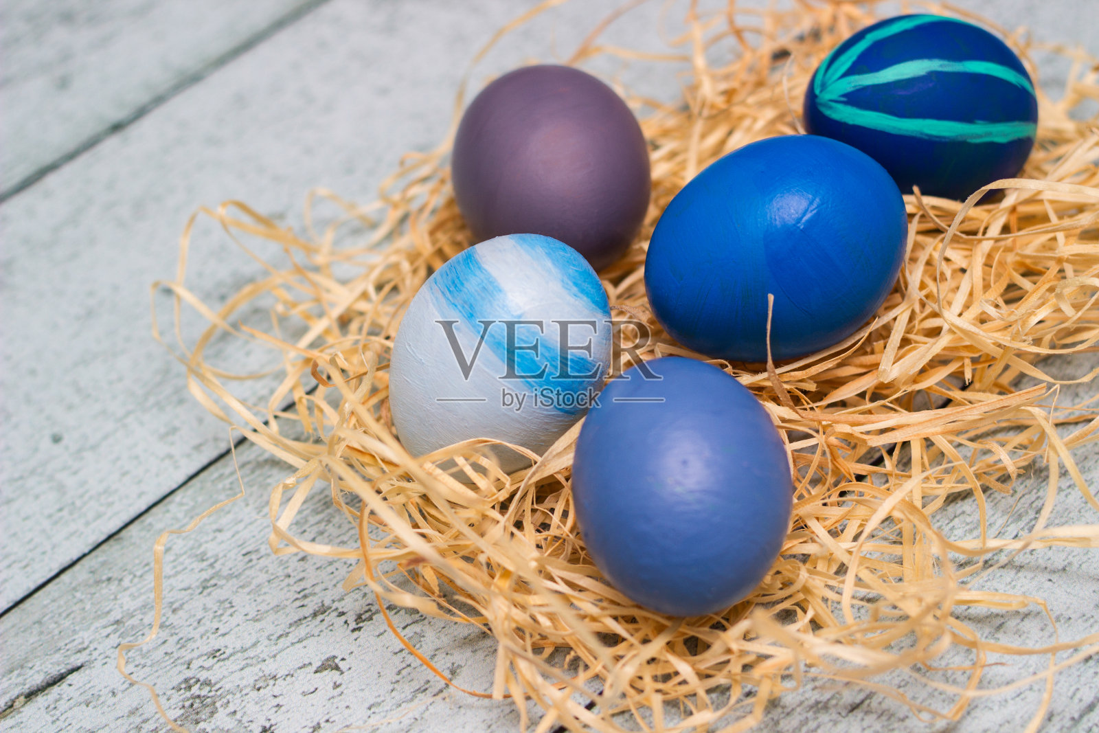 蓝色装饰复活节彩蛋在稻草巢照片摄影图片