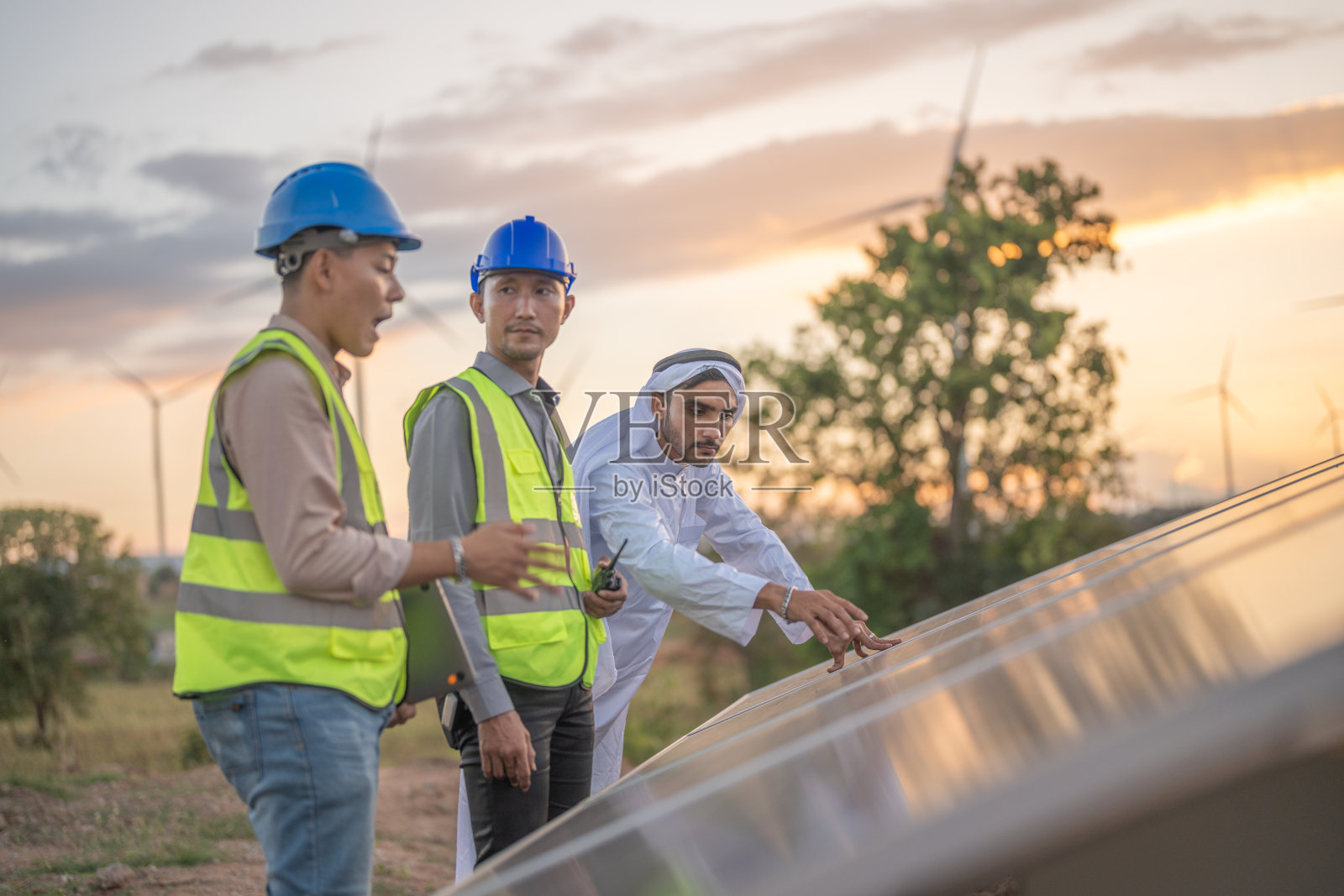 工程师通过电子设备检查太阳能电池板或光伏电池的施工。工业可再生能源的绿色动力。工厂工人在塔顶工作。照片摄影图片