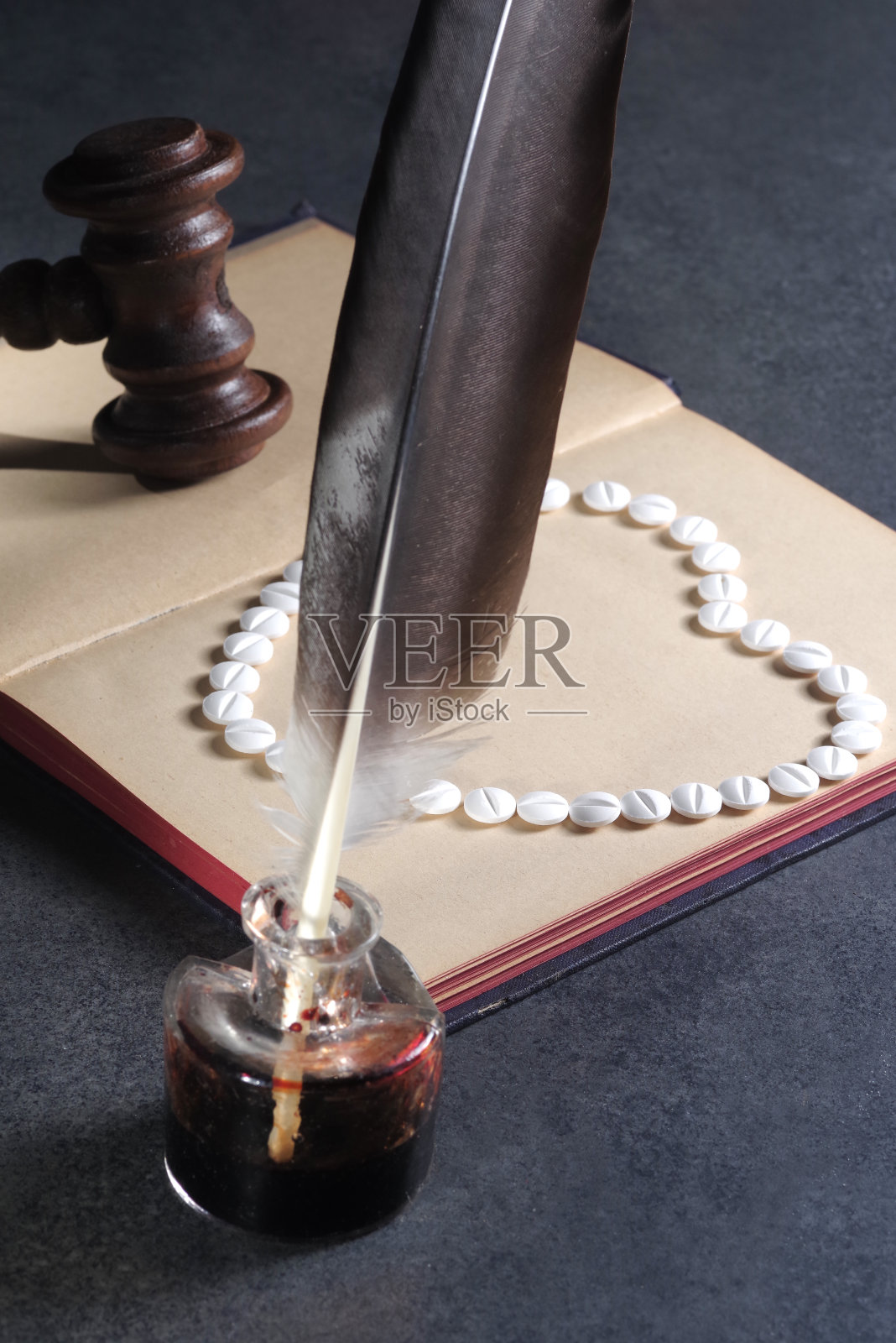 药丸堆积成书本上的爱心符号：医疗法律概念照片摄影图片