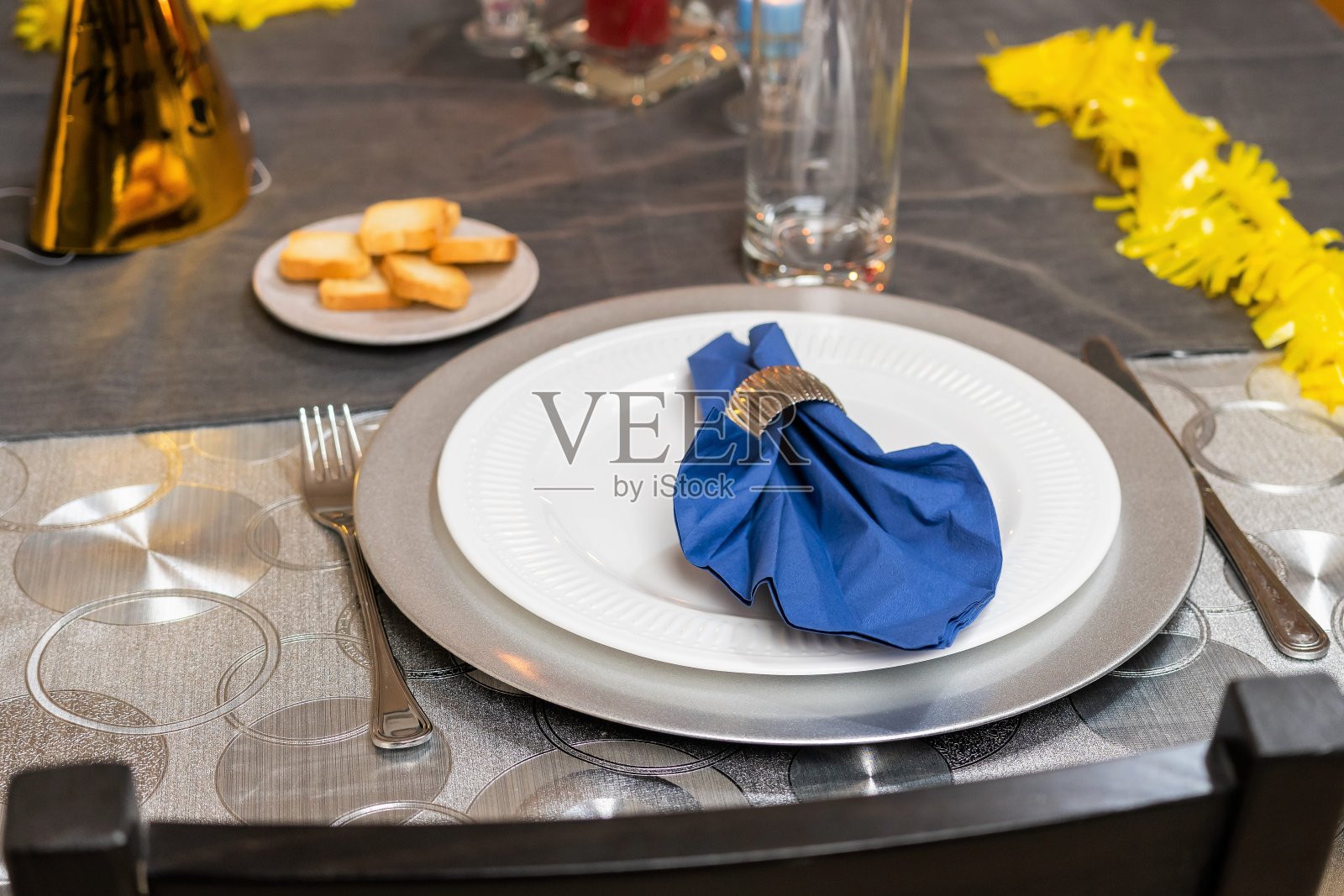 餐厅里为节日晚餐准备的优雅餐桌。白色的盘子，餐巾和玻璃器皿。照片摄影图片